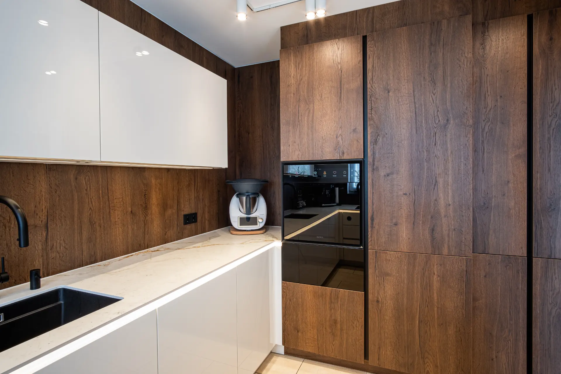 Grifflose Designküche in U-Form – Keramik und Nussbaum