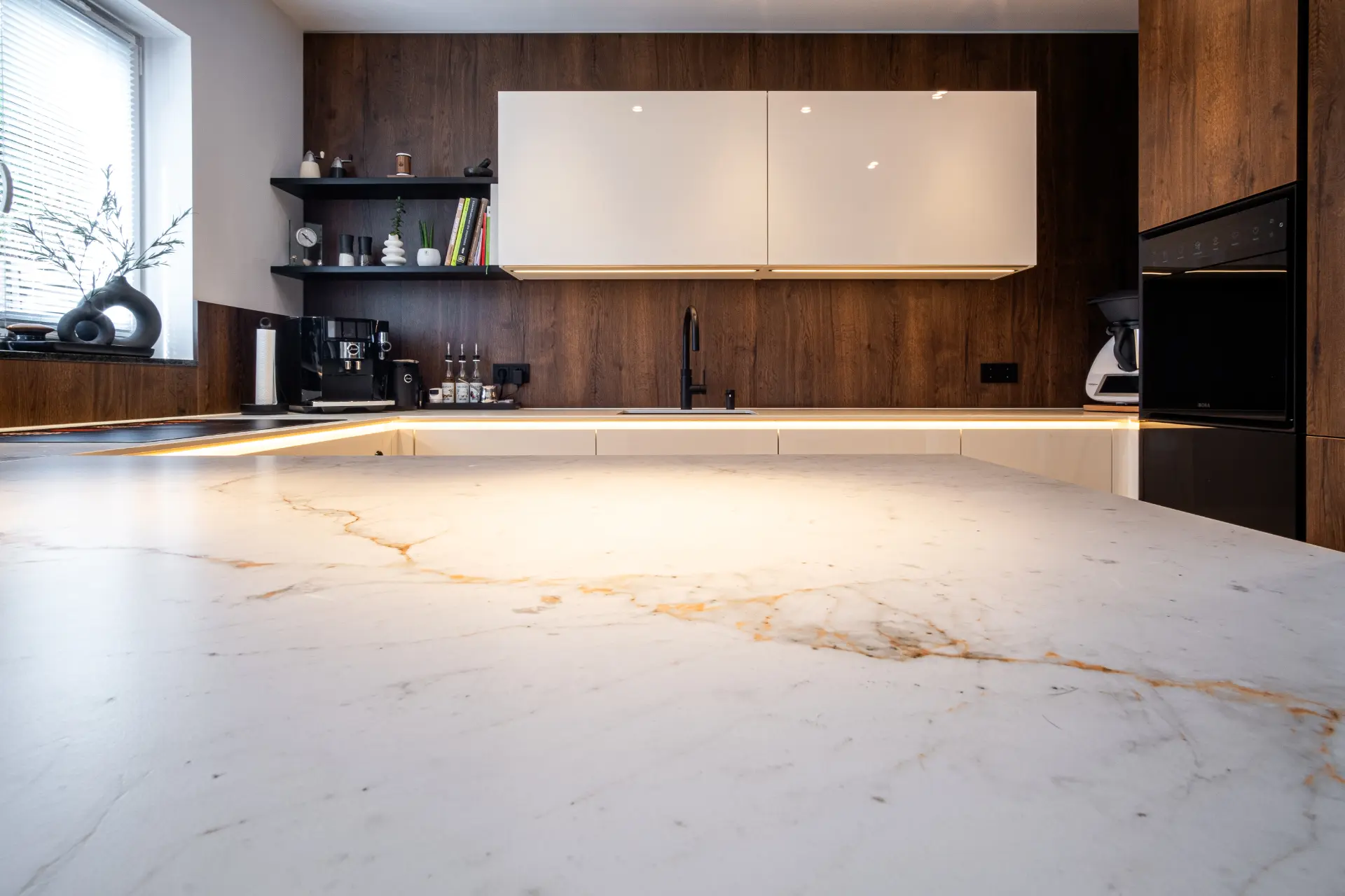 Grifflose Designküche in U-Form – Keramik und Nussbaum