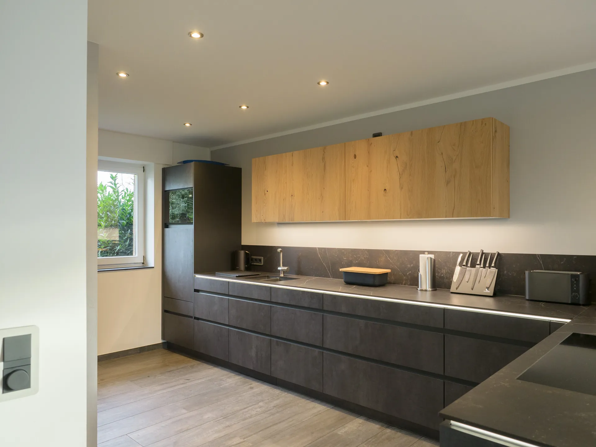 Designküche in Betonoptik – Grifflose Küche mit Hängeschränken