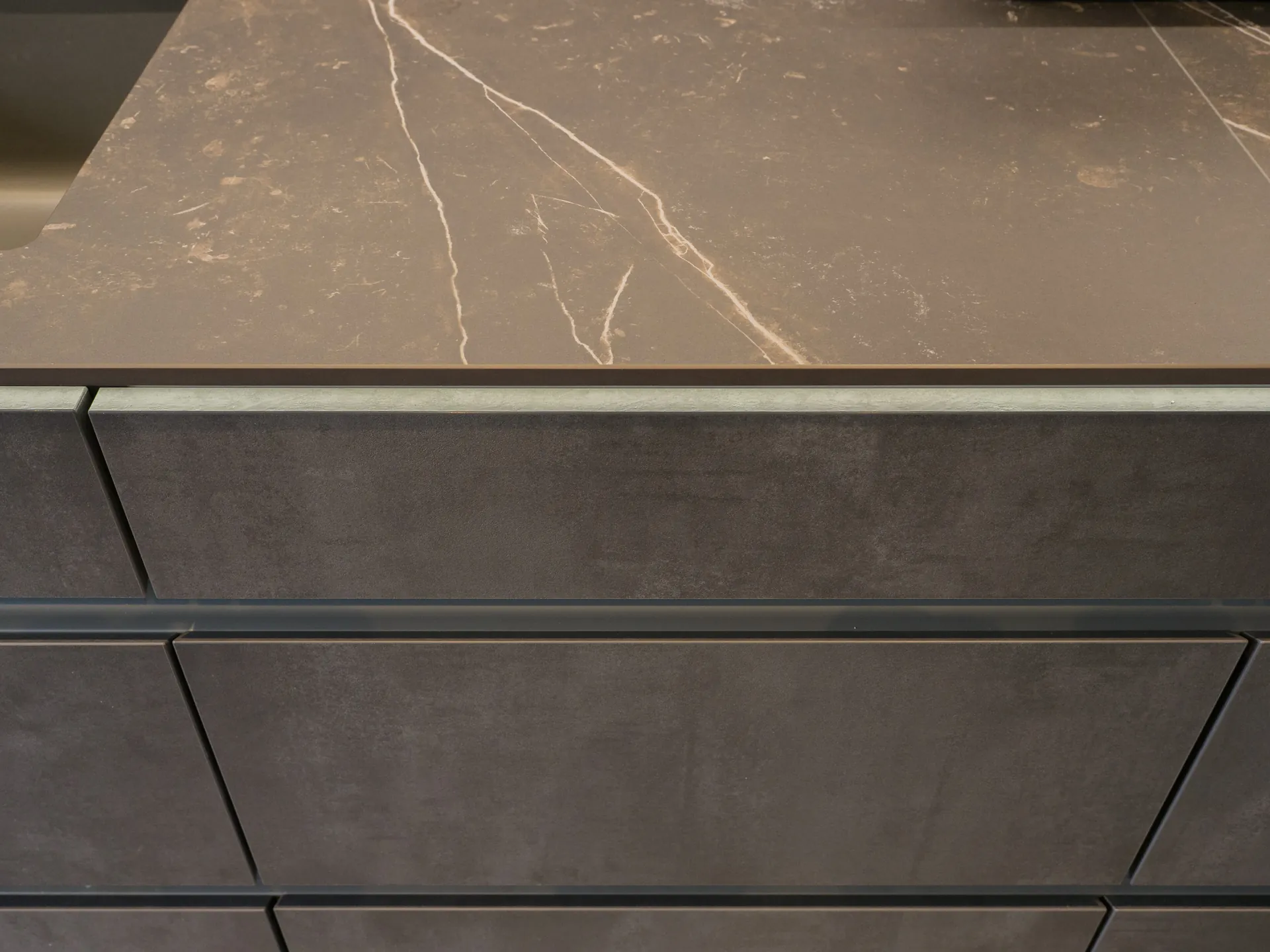 Designküche in Betonoptik – Grifflose Küche mit Hängeschränken