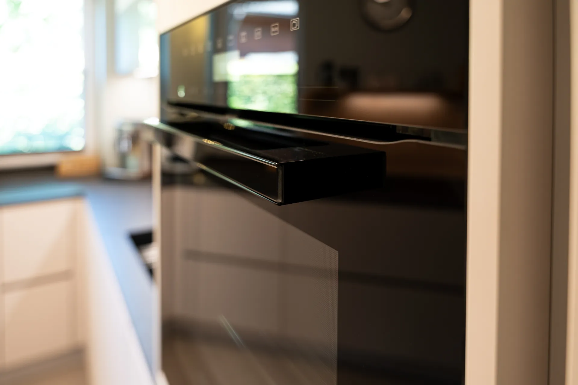 Grifflose Schreinerküche in U-Form – Keramik mit Quooker und Miele