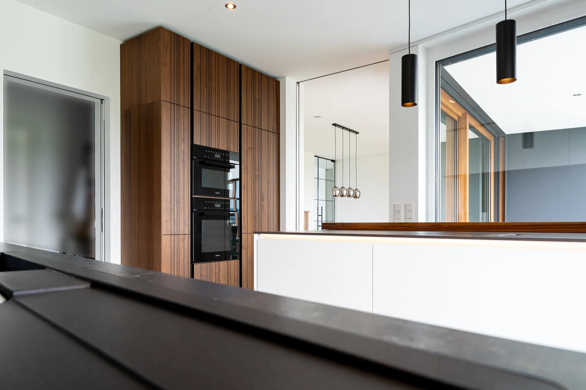 Grifflose Designküche mit Insel – Weiß, Holz und Keramik