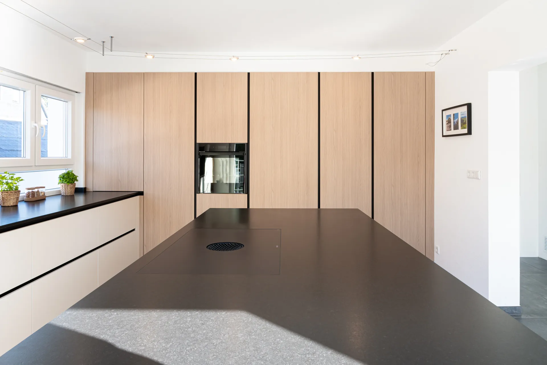 Grifflose Designküche mit Insel – Feineiche und Naturstein
