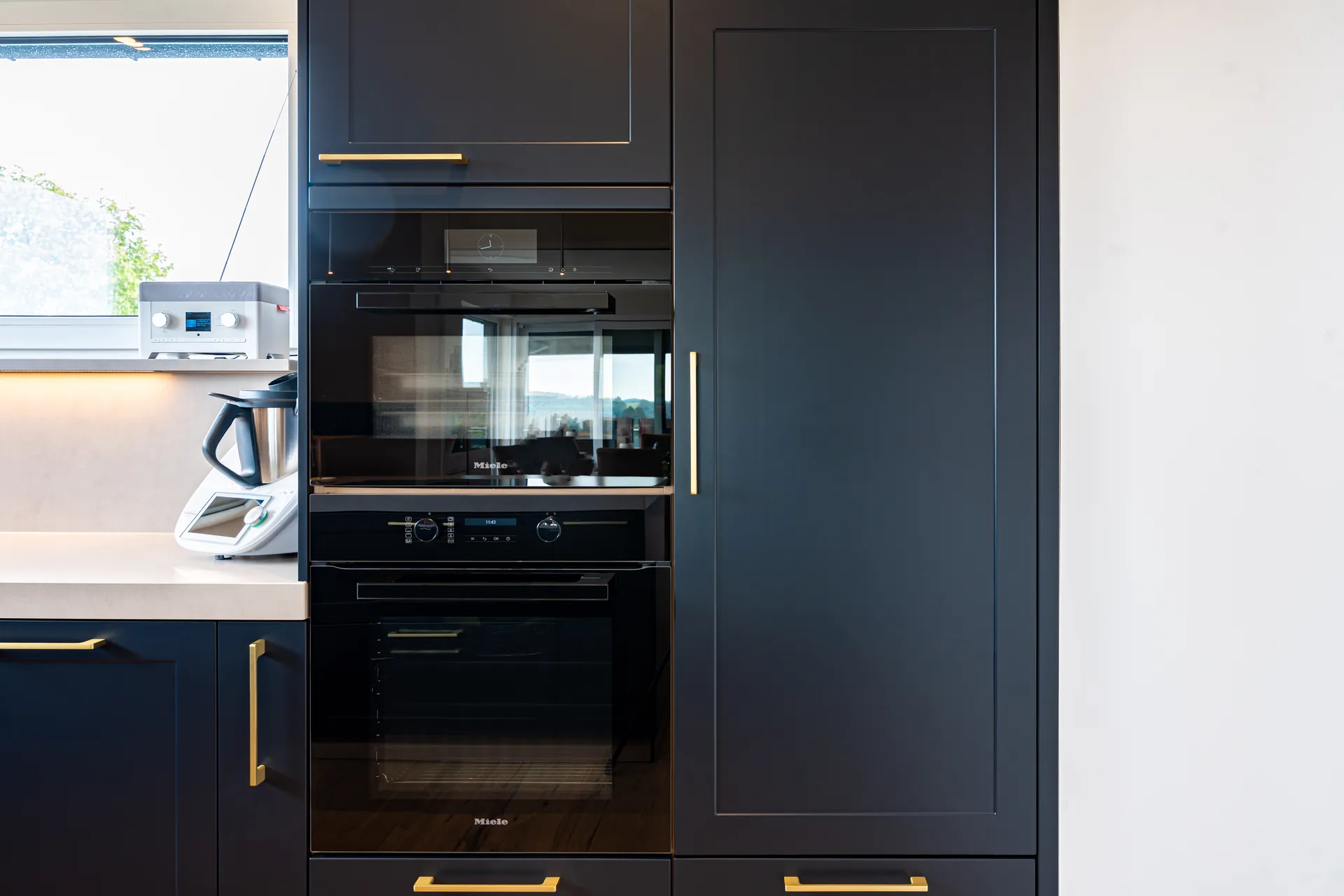 Designküche in U-Form – Blau mit Holz und Keramik