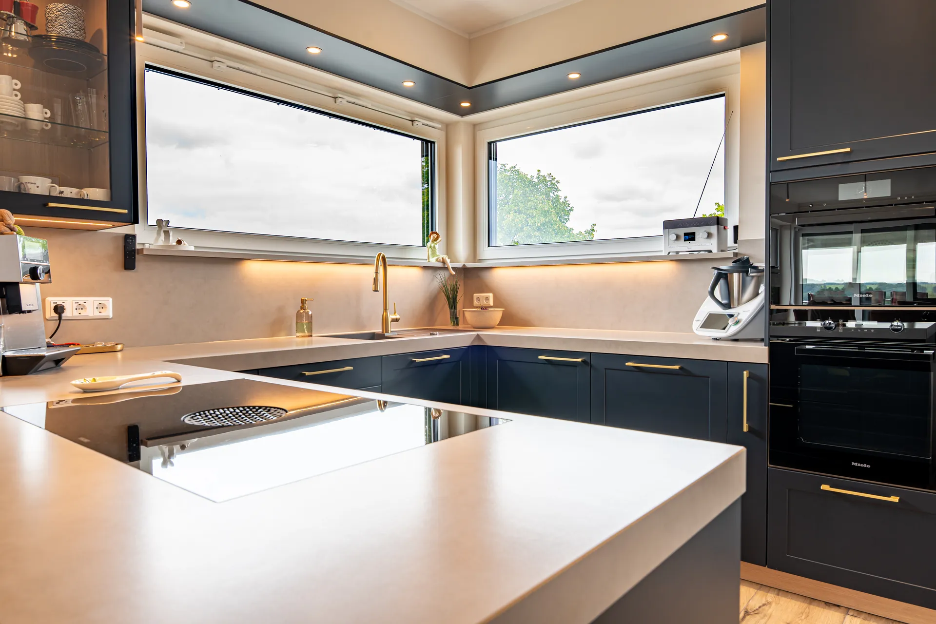 Designküche in U-Form – Blau mit Holz und Keramik