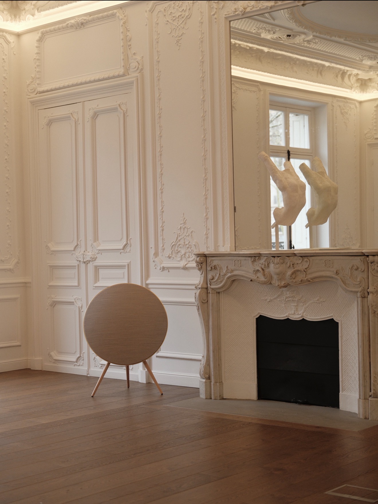Two dancers in red leggings performing an acrobatic pose on white sand dunes near a blue water body under a cloudy sky.