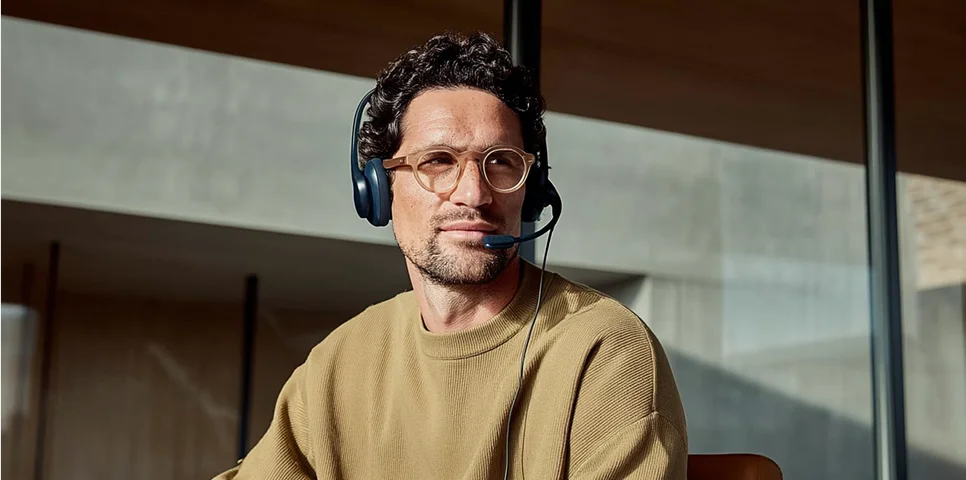 IT-Professional mit Headset lächelt im Büro – Symbolbild für erfolgreiche Jobvermittlung und Bewerbungsbegleitung durch ForTech Consulting.