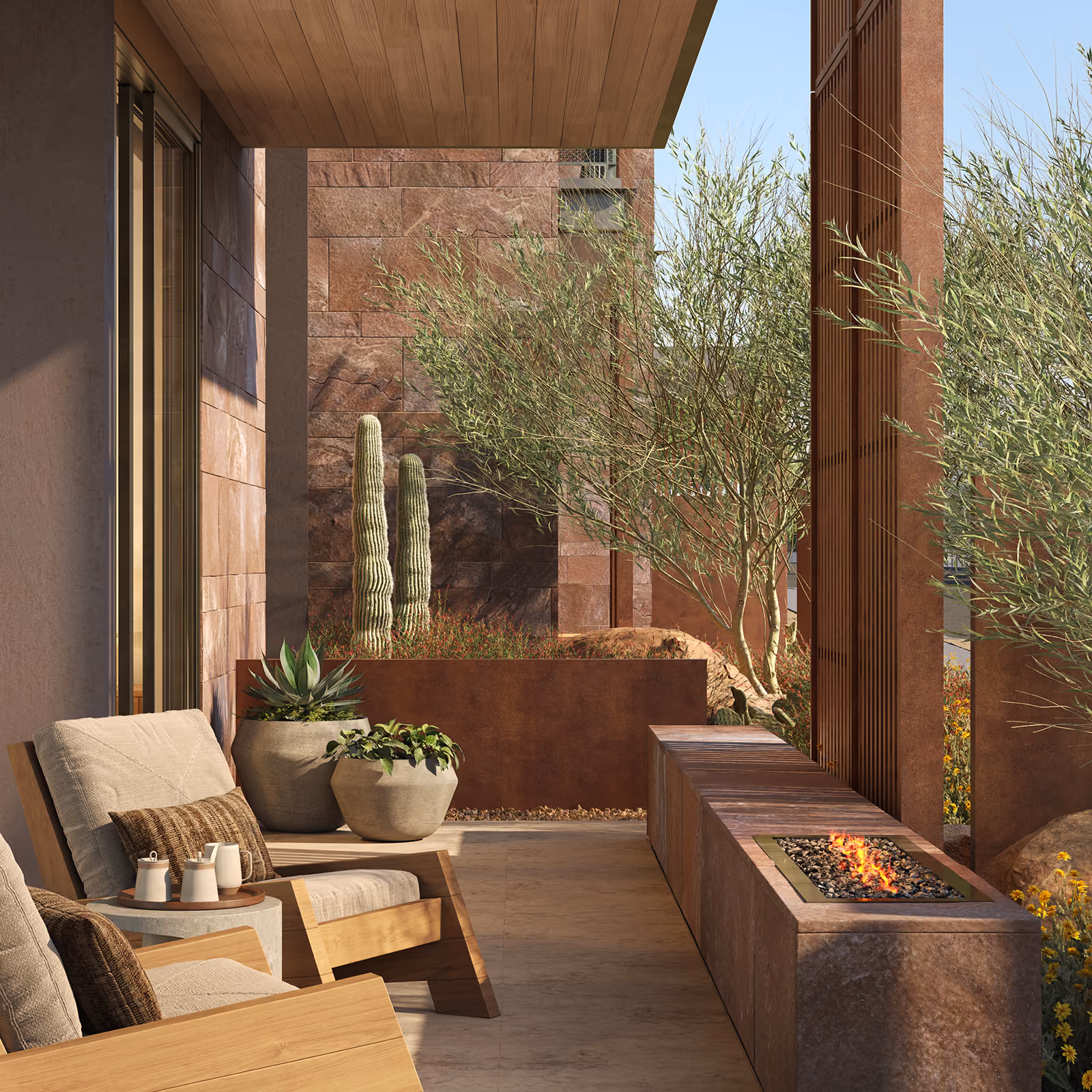 Outdoor patio with cushioned chairs, potted plants, and a modern fire pit surrounded by desert landscaping.