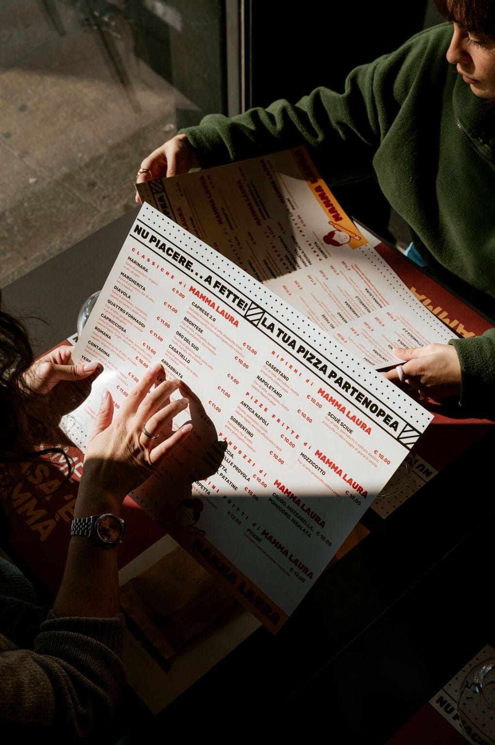 Two girls eating pizza at a home party