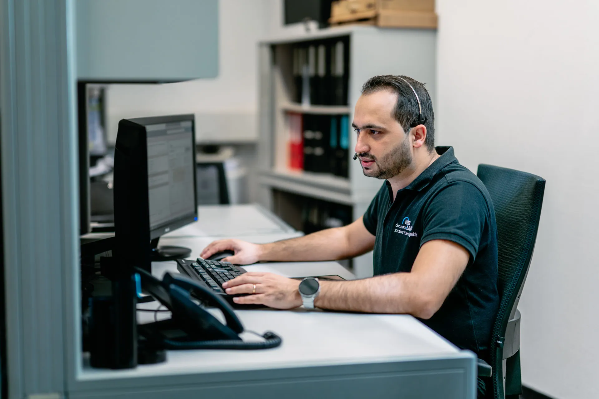 Mitarbeiter betreut Kunden am Arbeitsplatz