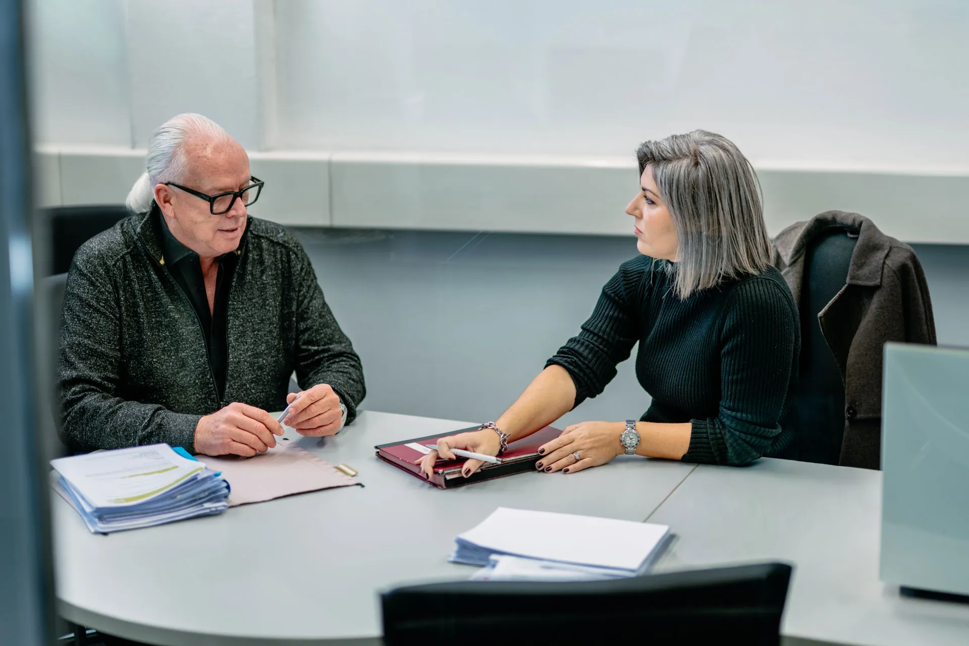 Mitarbeiterin berät einen Kunden zu Druck- und Scanlösungen im Büro in Graubünden