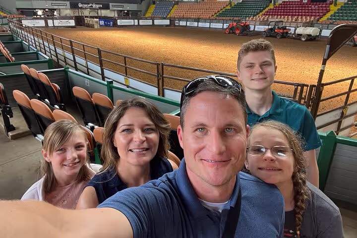 A family taking a selfie inside rodeo grounds