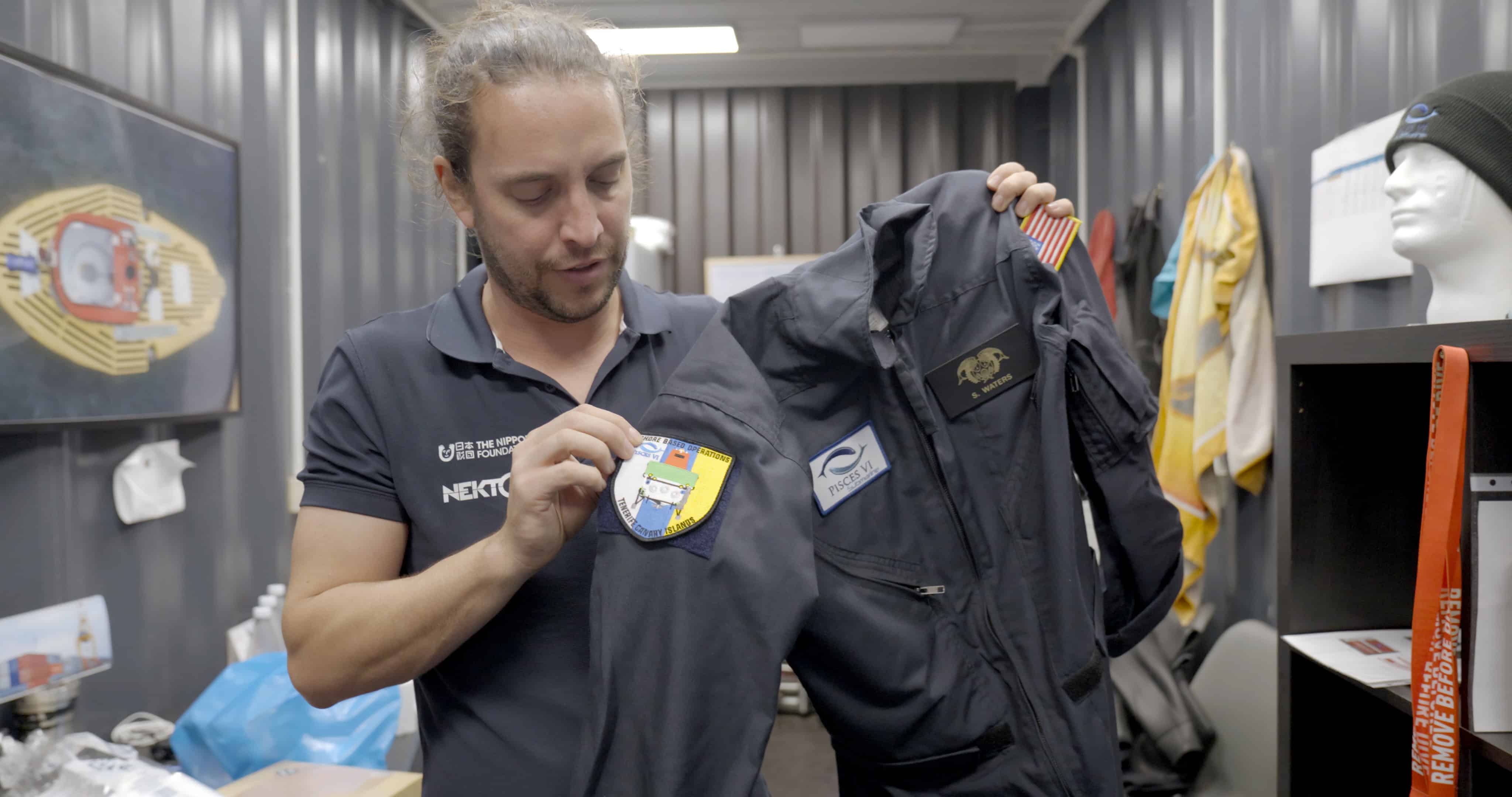 Scott holding up his submarine pilot uniform