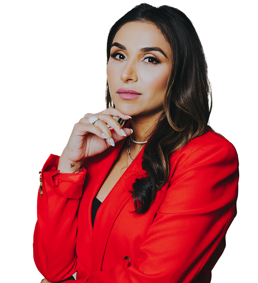 Woman with long dark hair wearing a red blazer, resting her chin on her hand with a thoughtful expression.