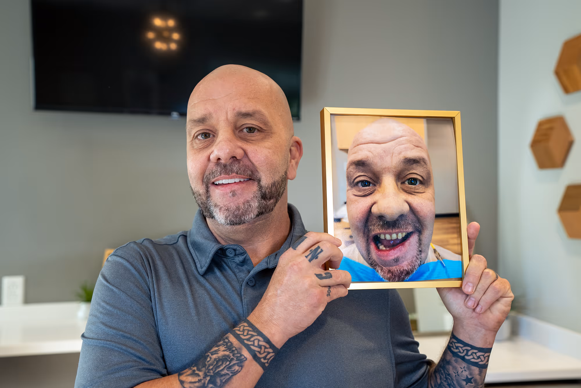 A man holding up a picture of an old man.
