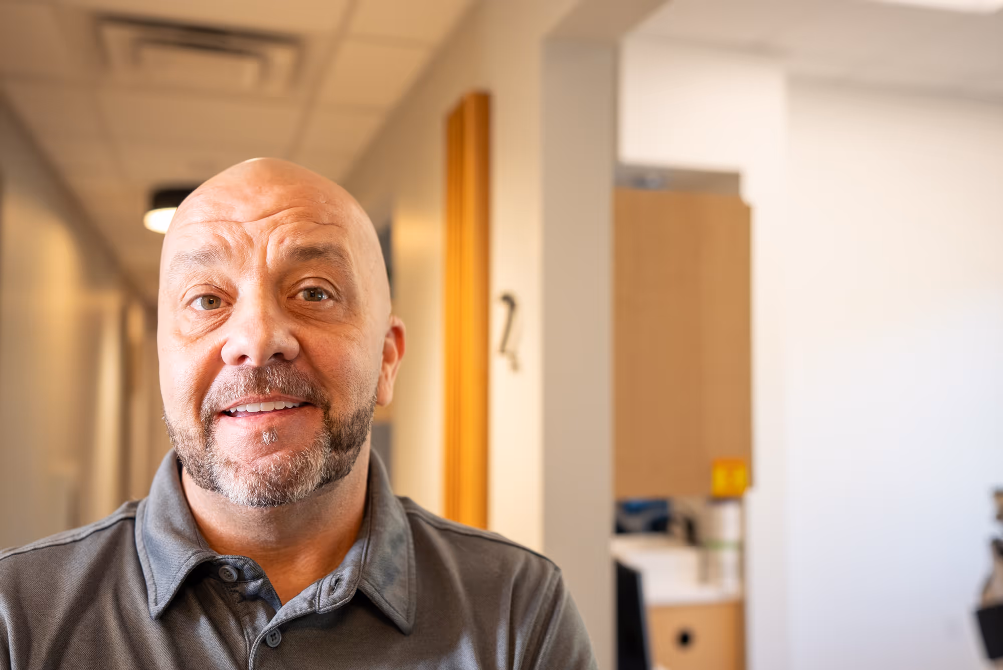 A man with a bald head is smiling.