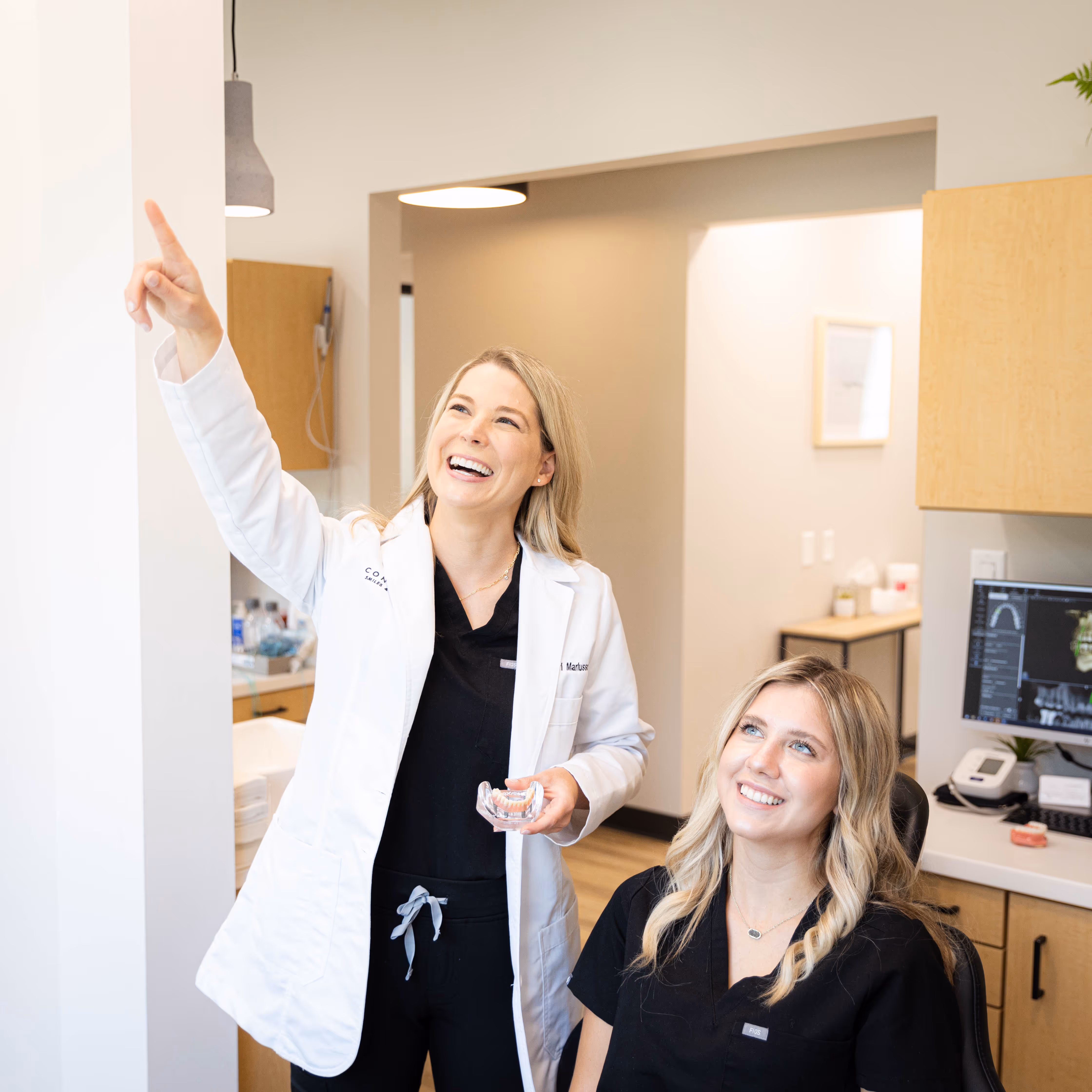 A woman standing next to a woman in a dentist's office.