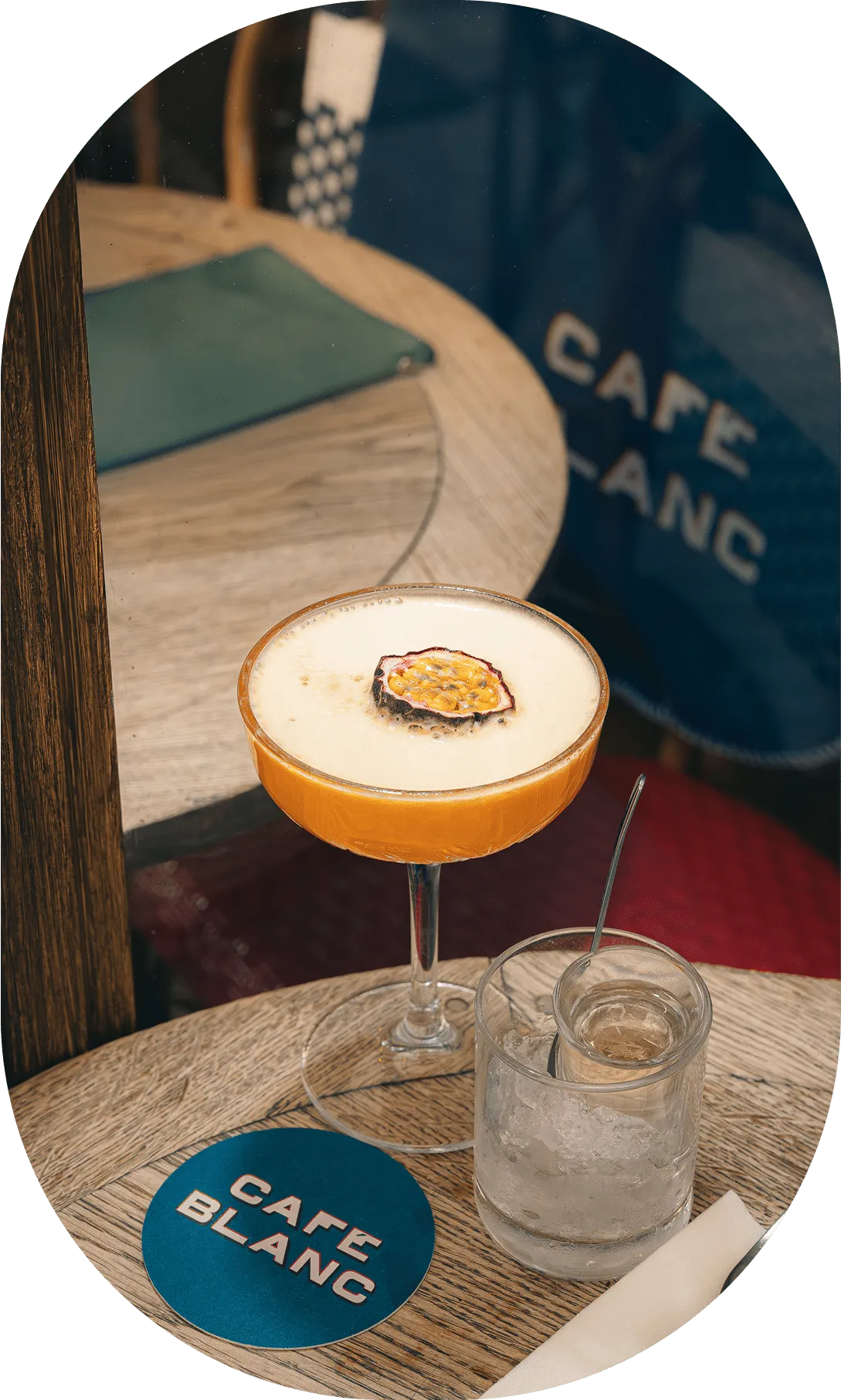 Cocktail signature du Café Blanc avec logo visible sur le dessous de verre