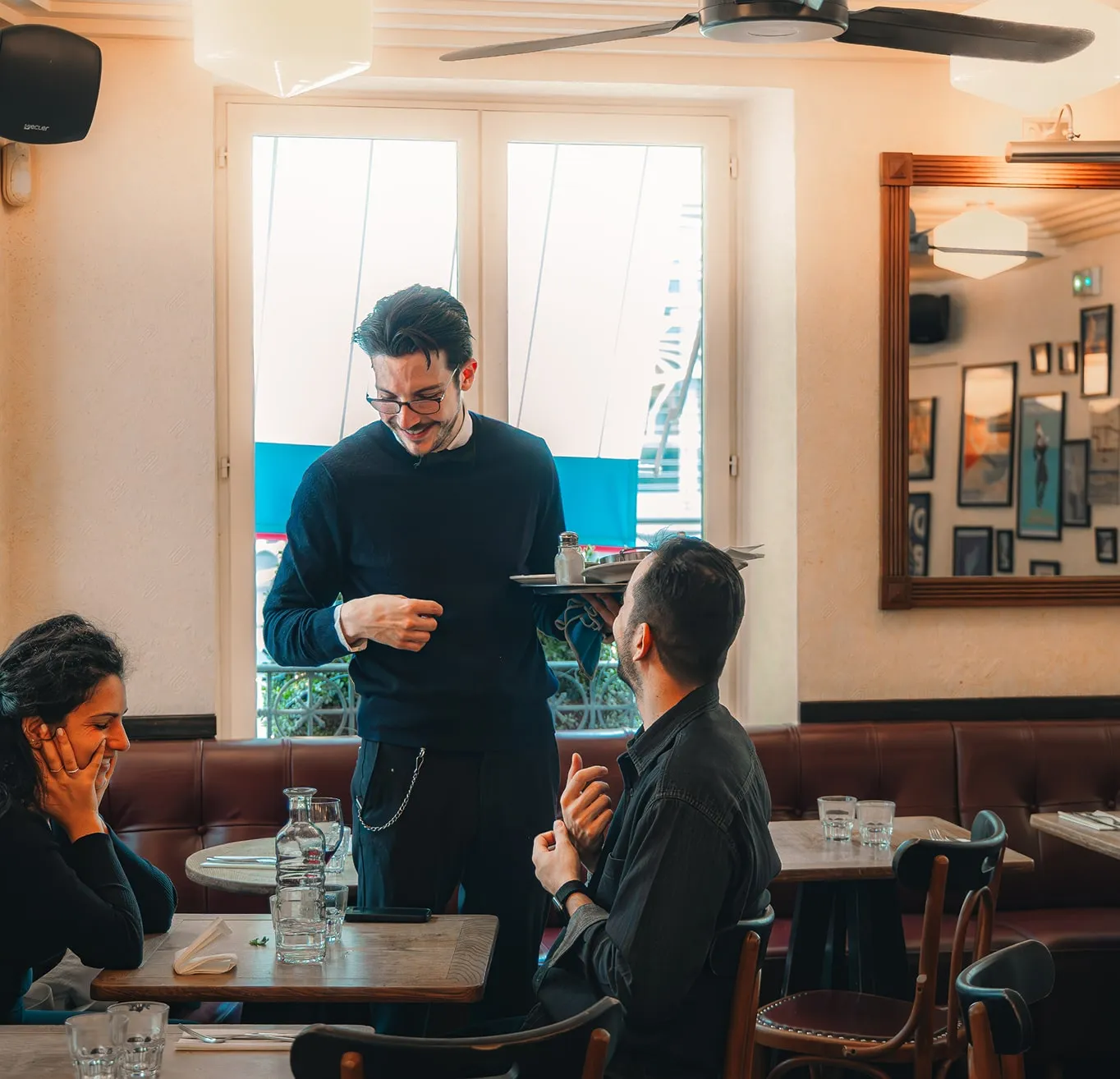 Serveur discutant avec des clients au Café Blanc pendant le service du midi