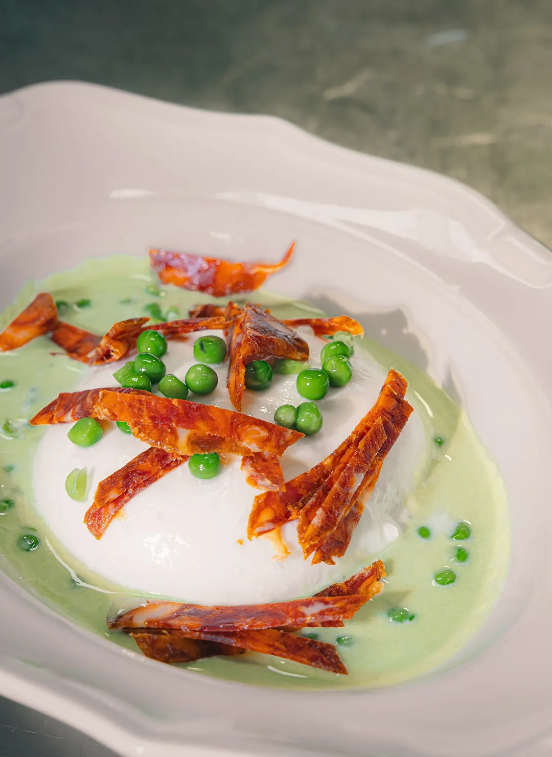 Burrata crémeuse avec petits pois et chips de jambon croustillant