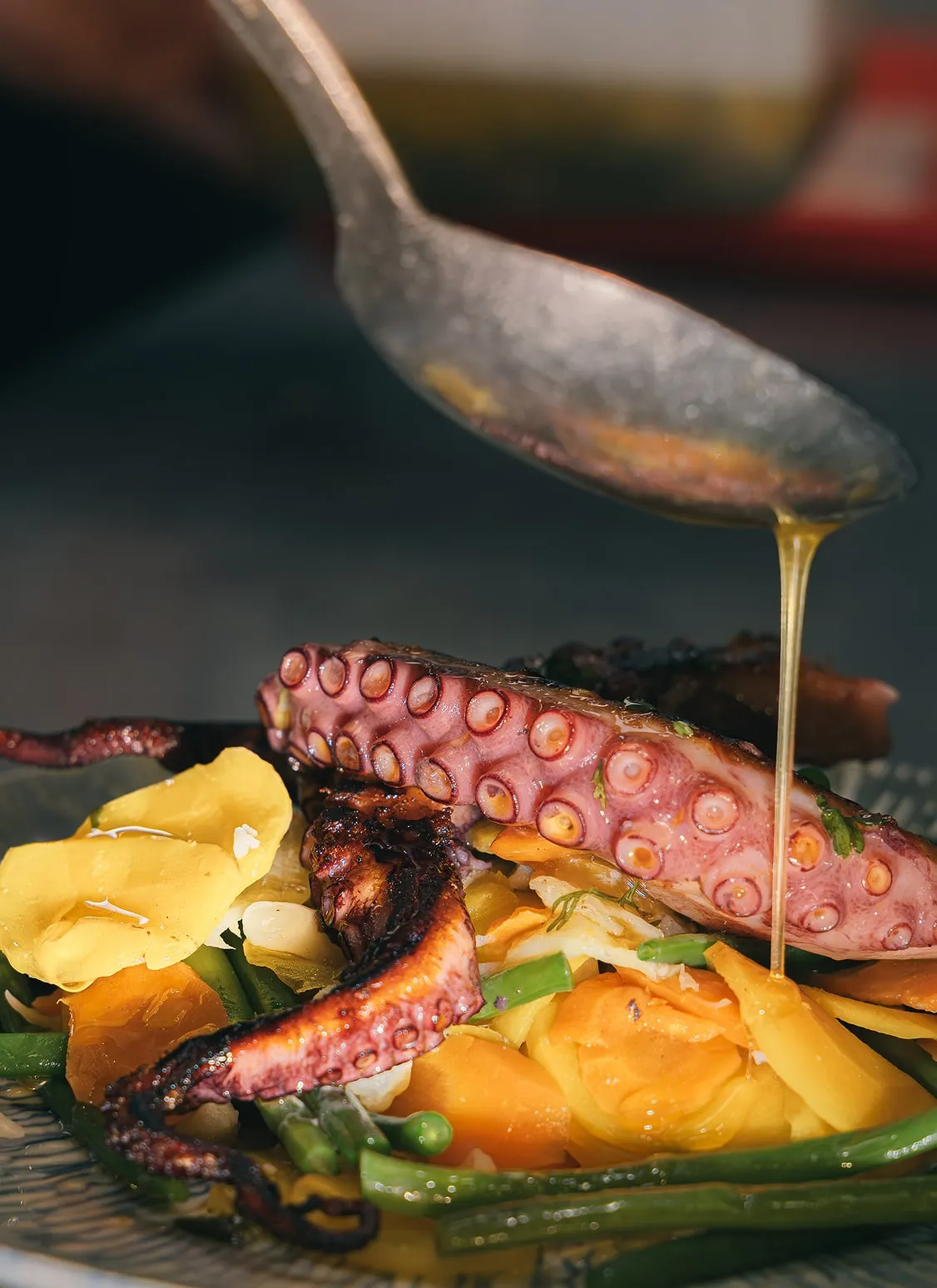 Poulpe grillé nappé d’une vinaigrette aux herbes au Café Blanc