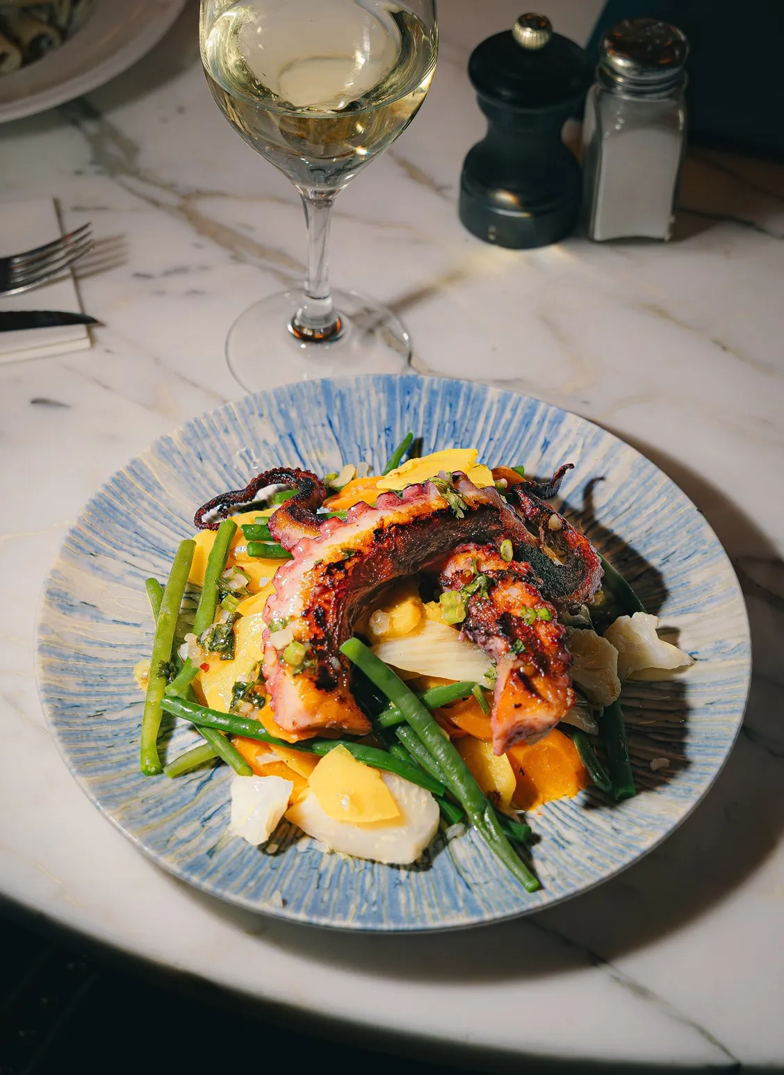 Poulpe grillé avec légumes de saison servi au Café Blanc