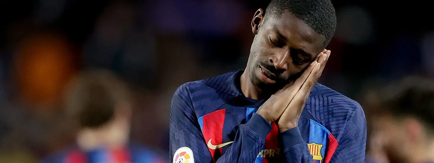 FC Barcelona player resting his head on his hands in a gesture of sleep or fatigue during a match.