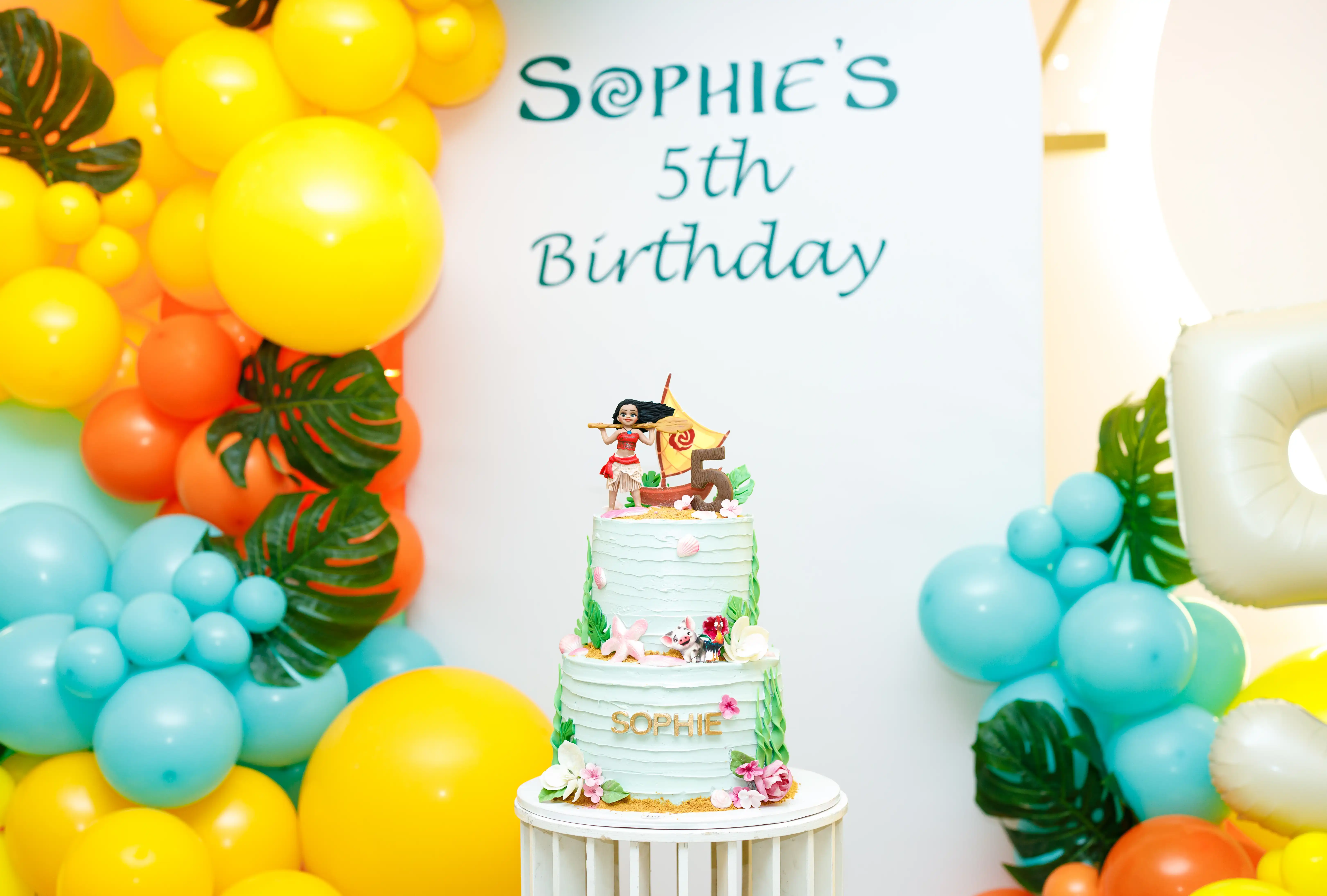 Children's events package banner featuring a custom tropical themed birthday cake topper with balloon garland décor for Perla Signature Events luxury kids party planning services in Yerevan, Armenia