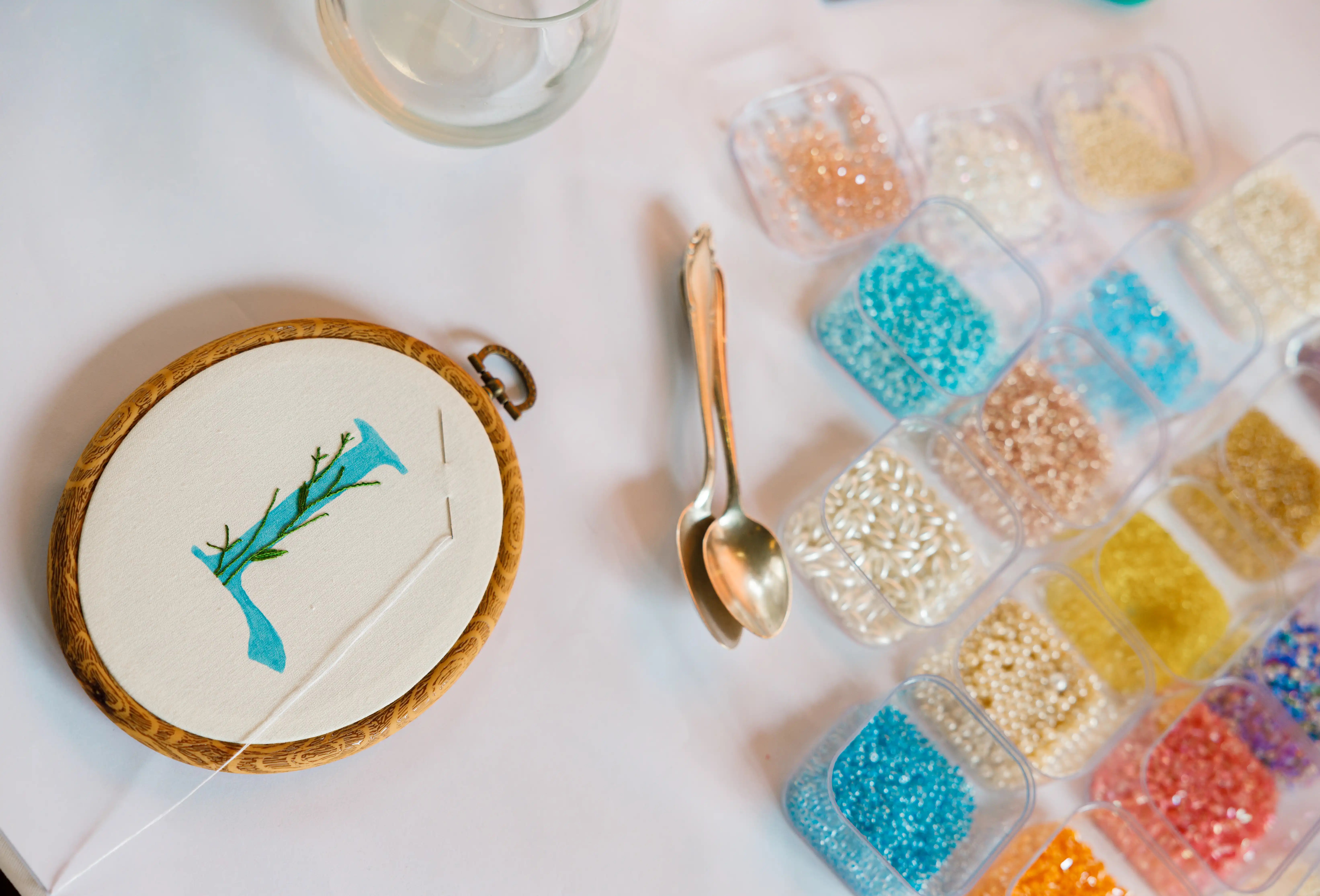 Corporate events package banner featuring an artisan embroidery hoop and colourful seed bead workshop setup representing Perla Signature Events luxury corporate event planning services in Yerevan, Armenia