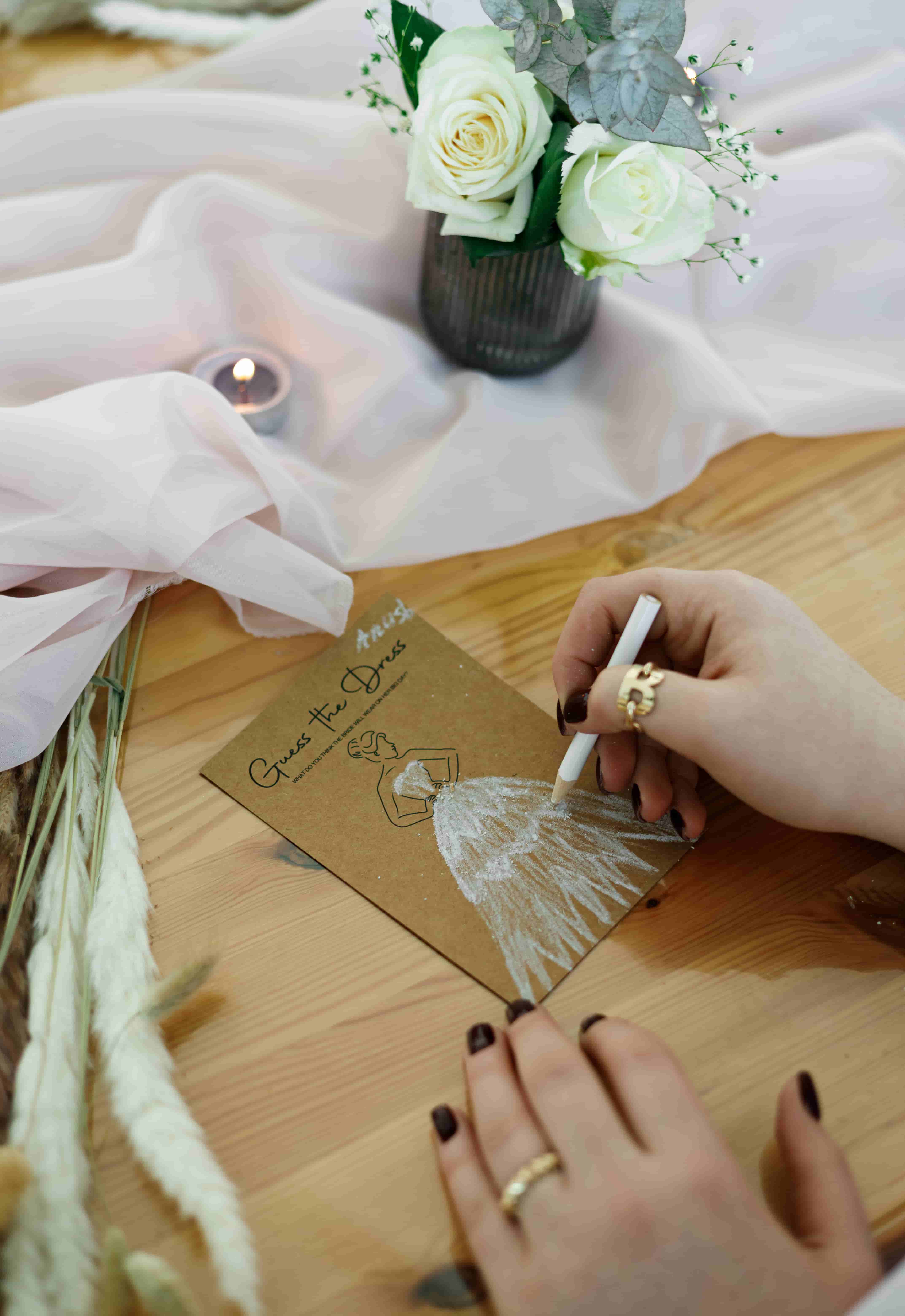 Guest drawing a bridal gown on a `Guess the Dress` bridal shower activity card at a luxury wedding event by Perla Signature Events in Armenia