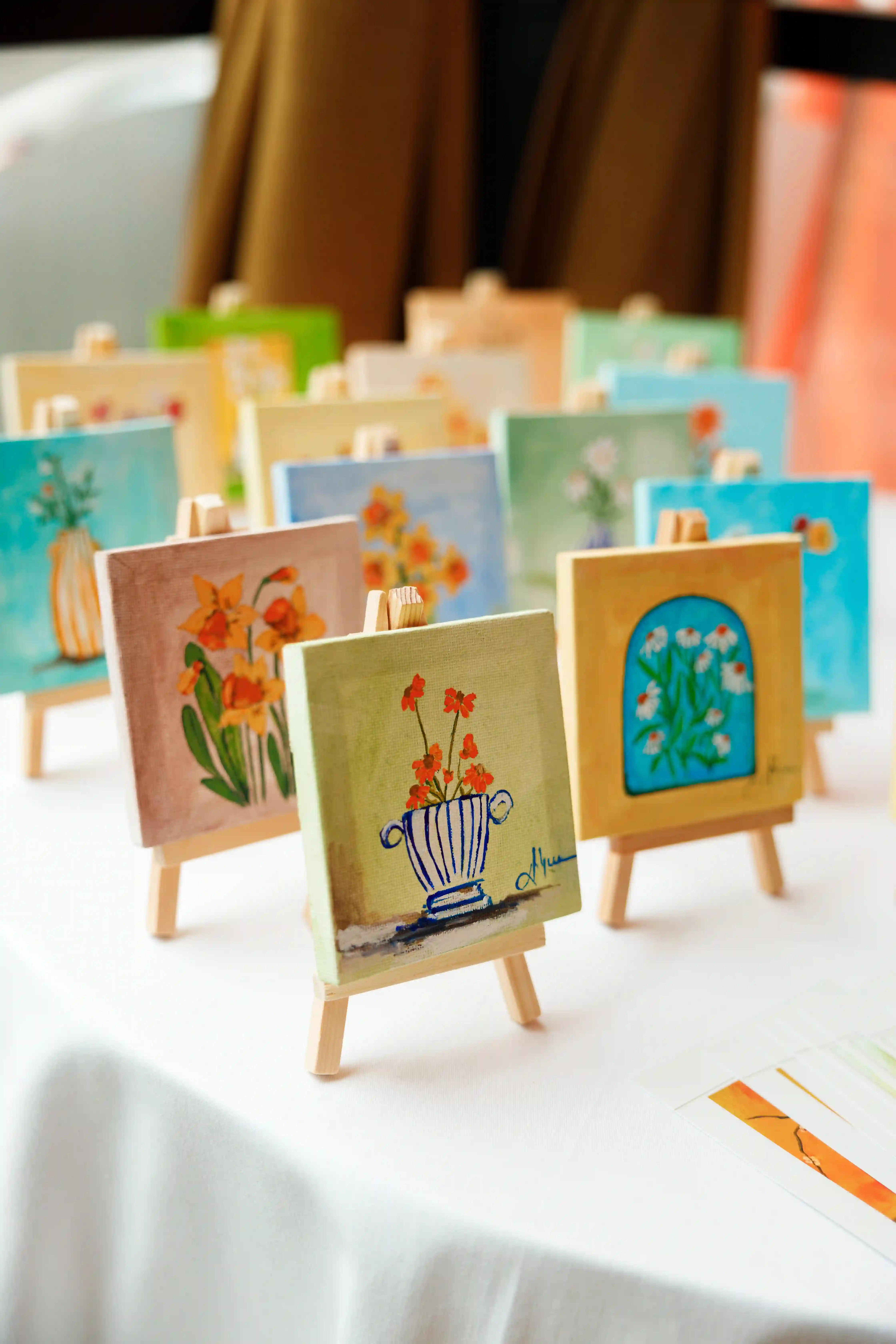 Mini hand-painted floral canvases displayed on wooden easels as guest gifts at a luxury event curated by Perla Signature Events in Yerevan, Armenia