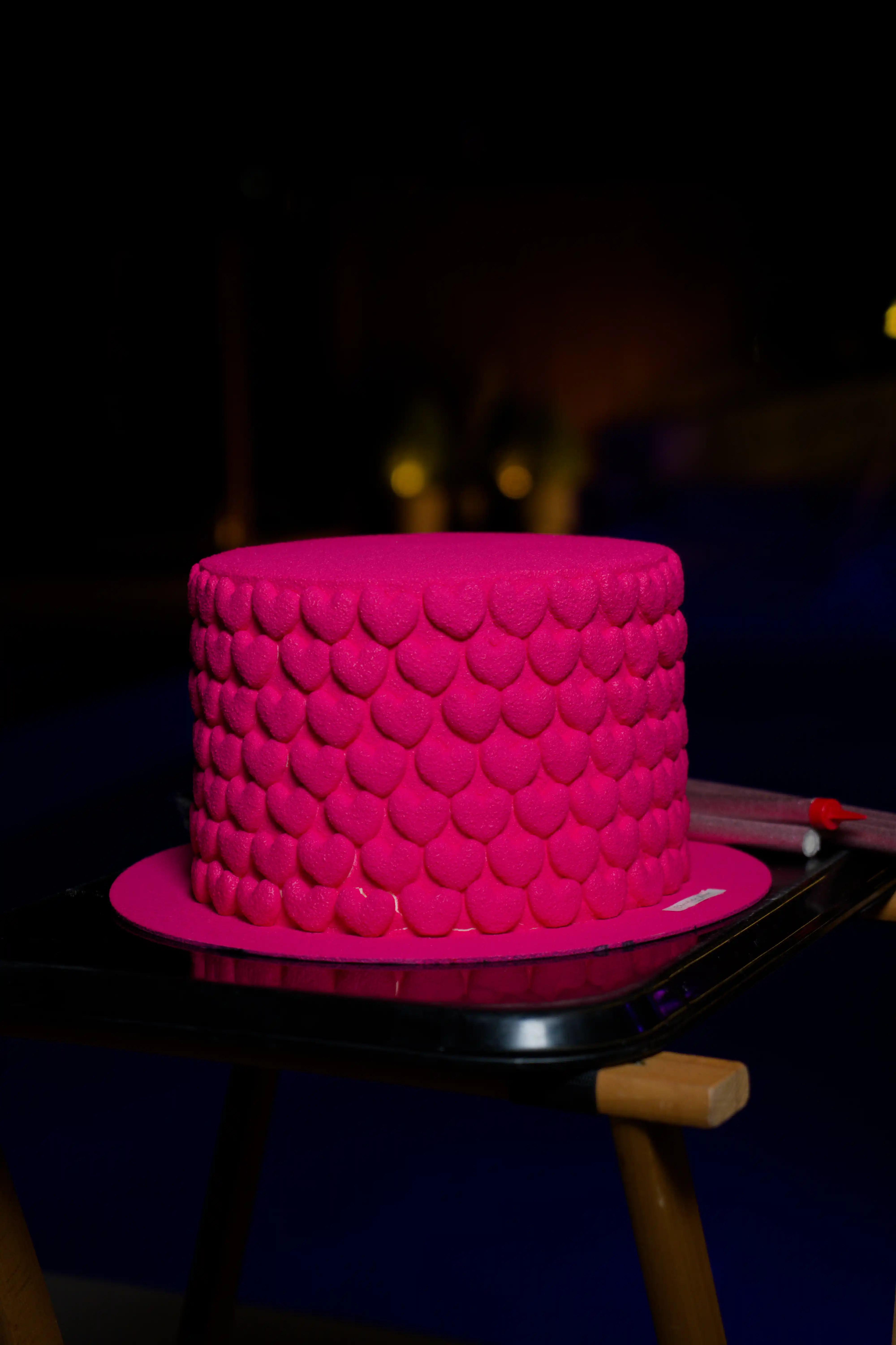 Bold hot pink textured fondant cake with scalloped petal pattern on a dark moody backdrop at a luxury event by Perla Signature Events in Yerevan, Armenia
