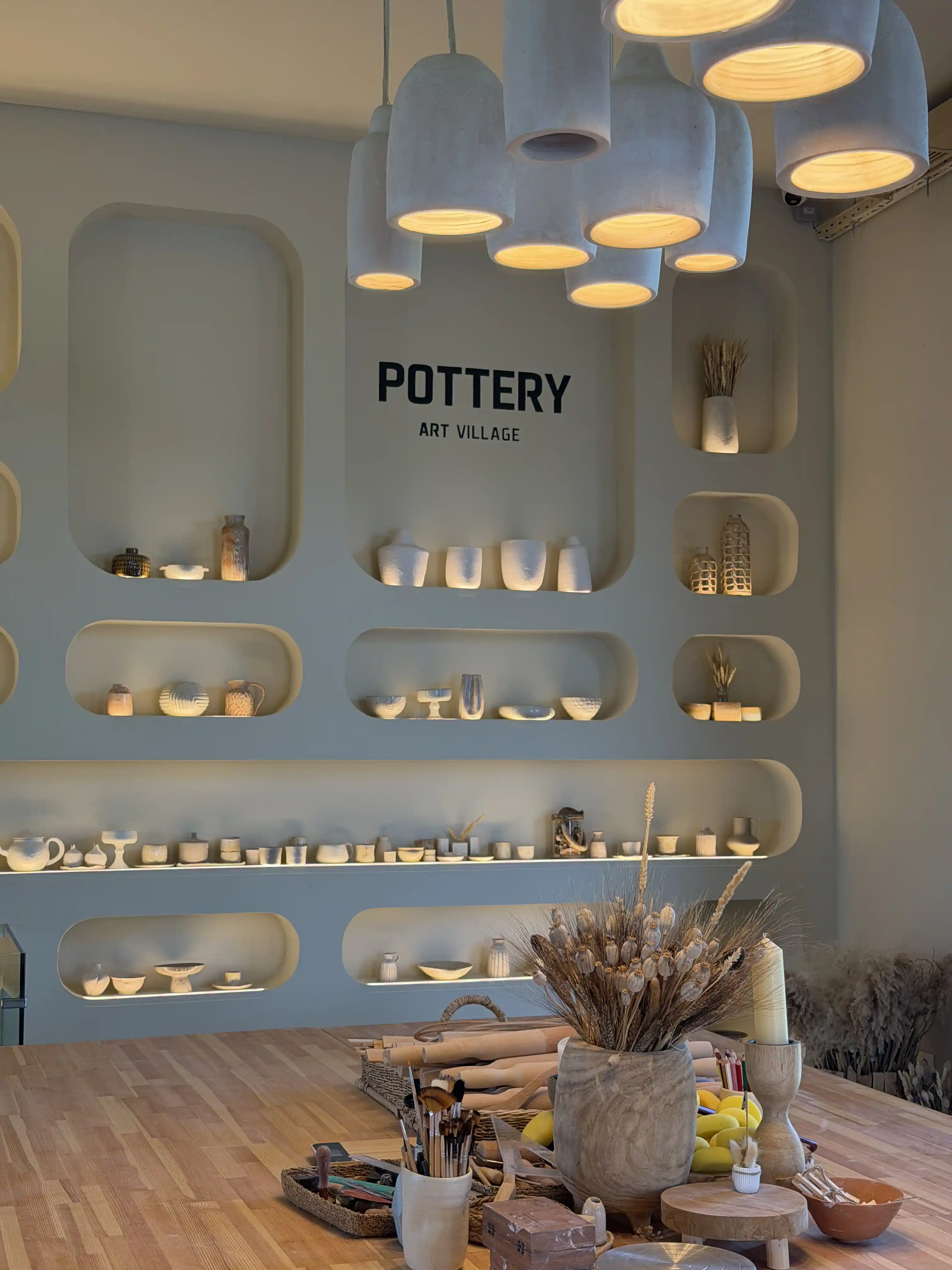 Pottery studio at Art Village with illuminated wall niches and handmade ceramics