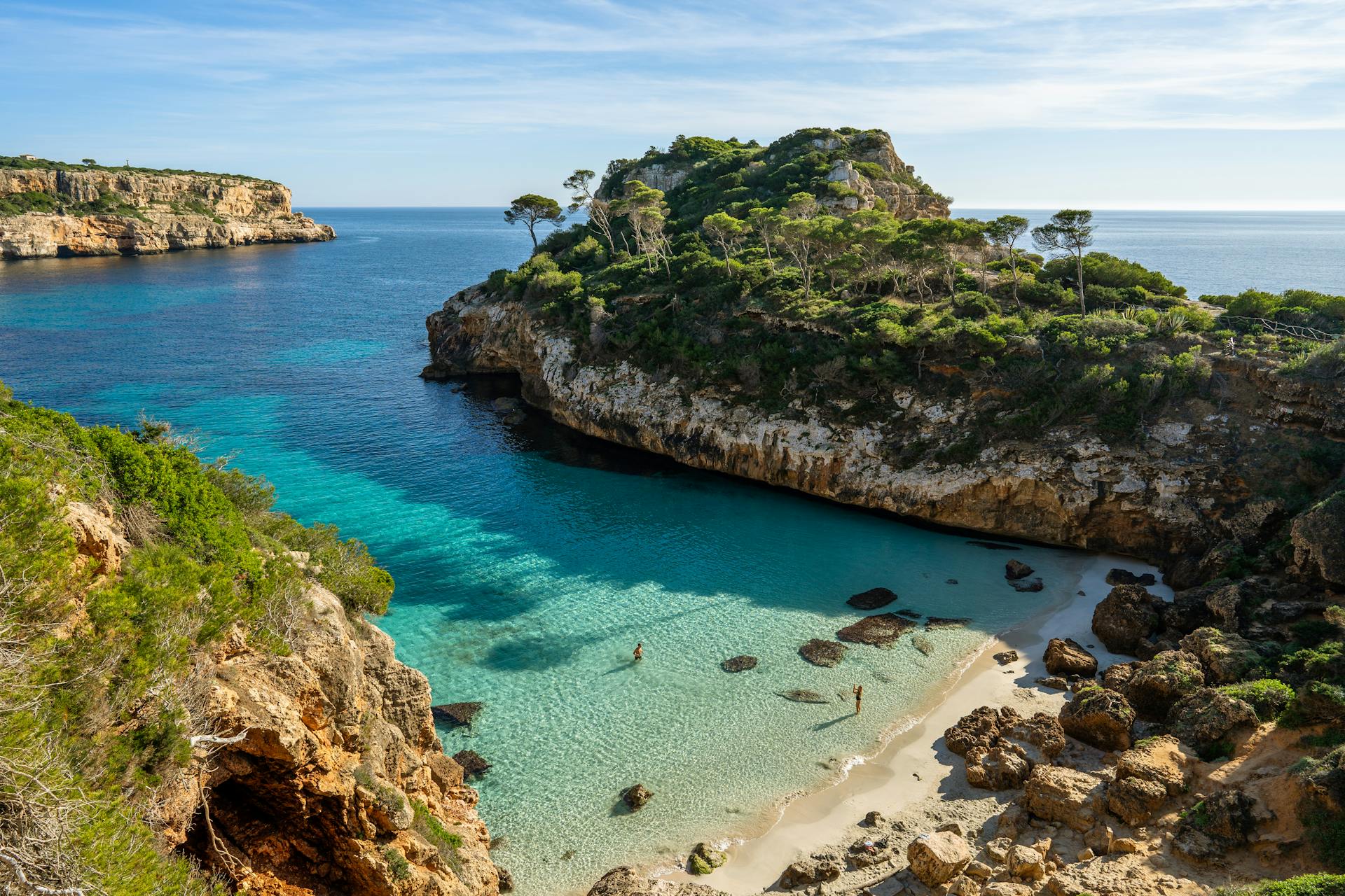 Famous bay in Mallorca with turquoise waters, rocky shores, and green shrubs along the coast