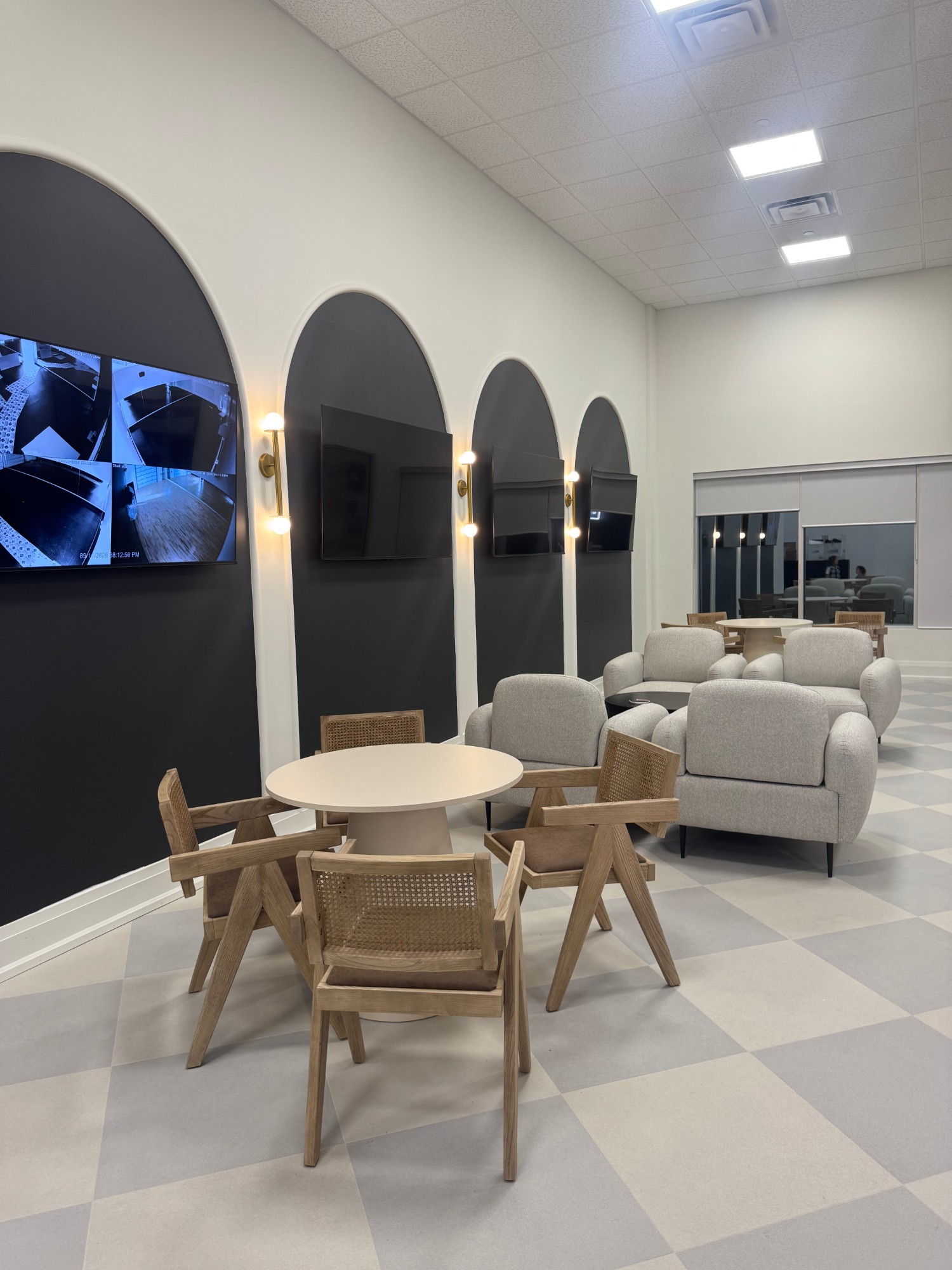 Arched viewing wall with screens and lounge seating at The NINE Dance Academy