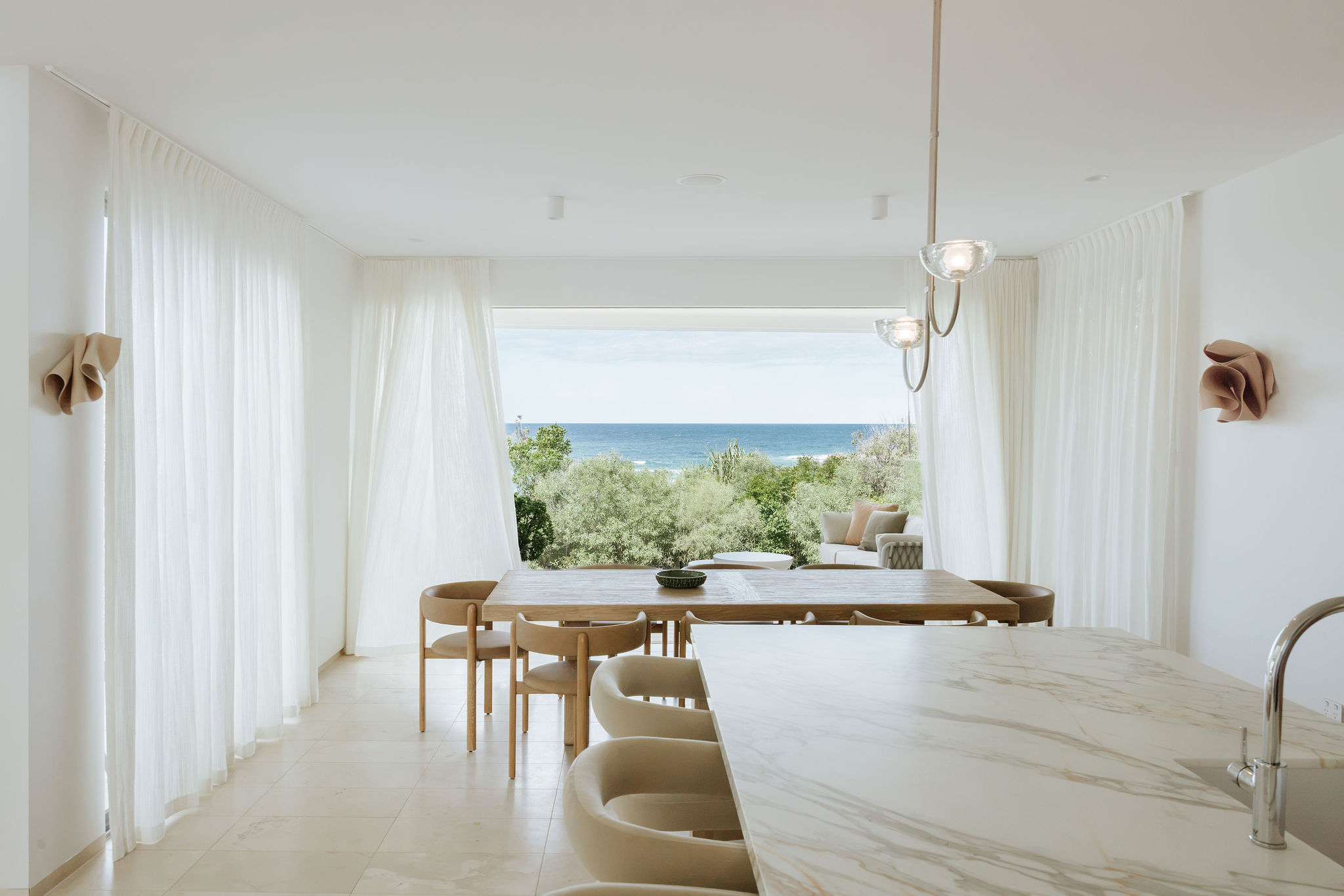 Feature pendant lighting over the island, kitchen, laundry and powder room renovation on Orient Drive, Sunrise Beach by Pearl Interiors, built with Nomad Builders, Franca Designs stone benchtops and Faucet Strommen tapware, Sunshine Coast