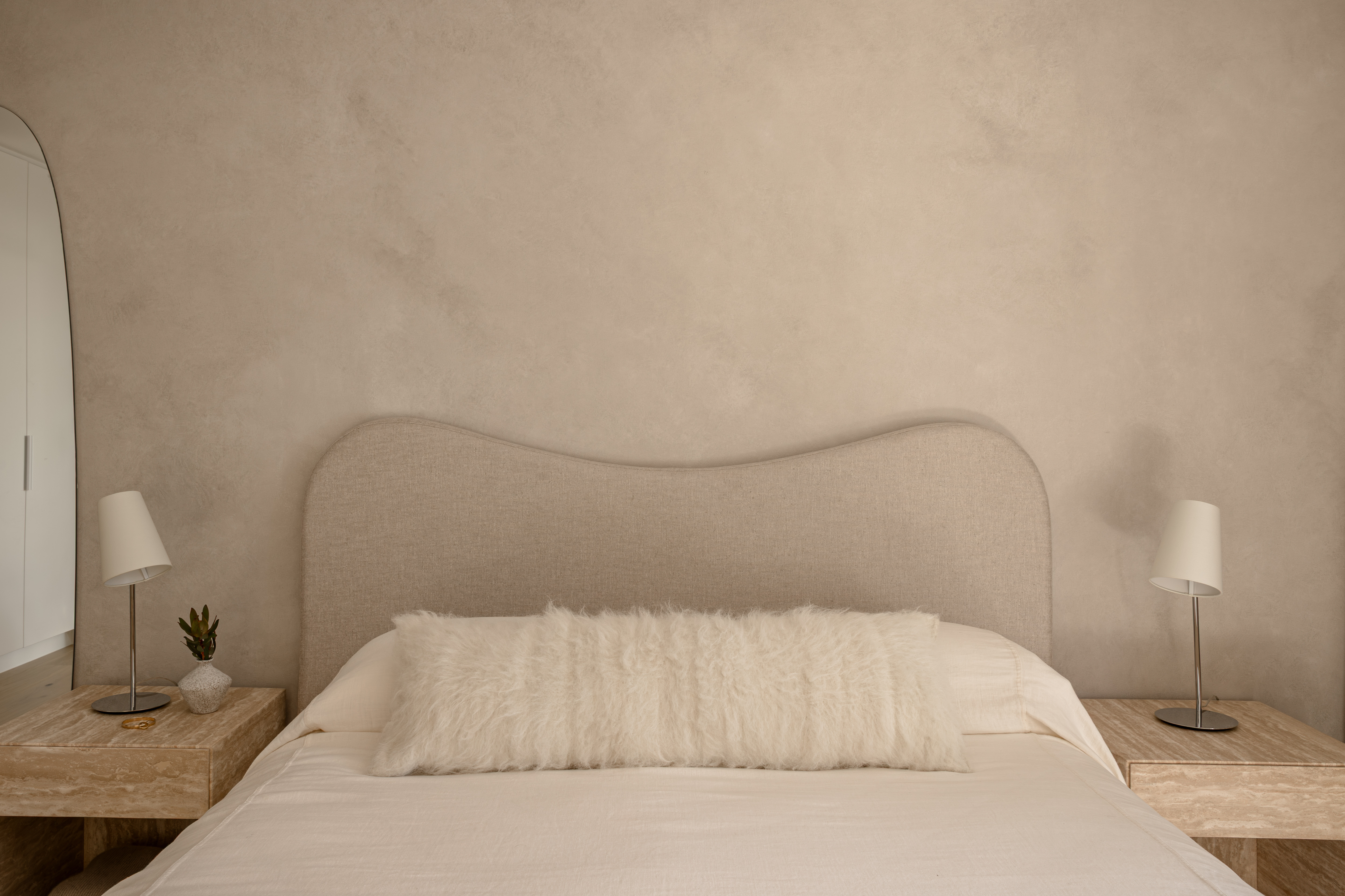 Master bedroom with curved upholstered bedhead, Edgar Bennett renovation in Noosa Heads by Pearl Interiors