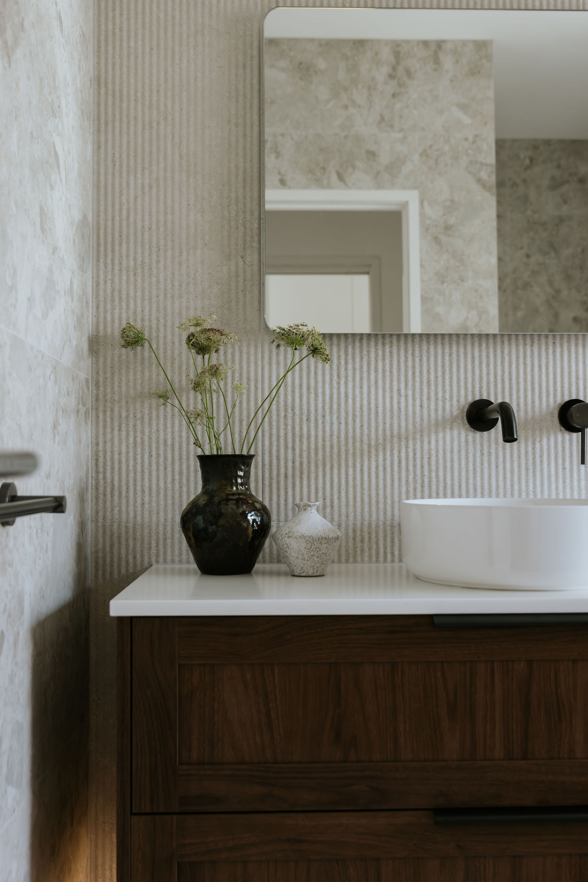Full-height tiling and stone surfaces in a Sunshine Coast bathroom renovation by Pearl Interiors