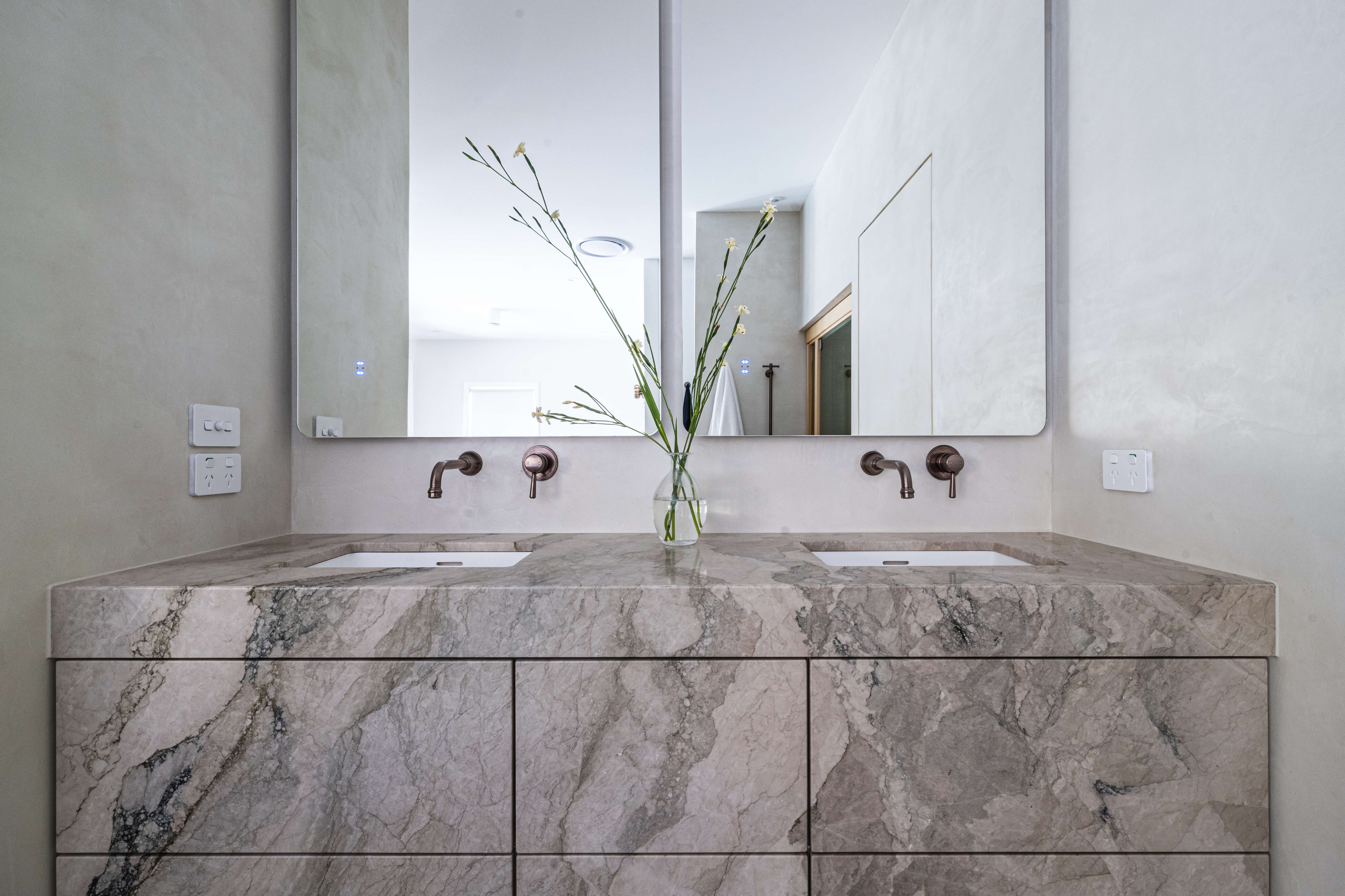 Bath beside a stone niche, moody spa-inspired parents' bathroom renovation in Timbeerwah, Noosa Hinterland by Pearl Interiors, built with Squire Development Group, Ace Stone and Tile stone tiling and Faucet Strommen tapware