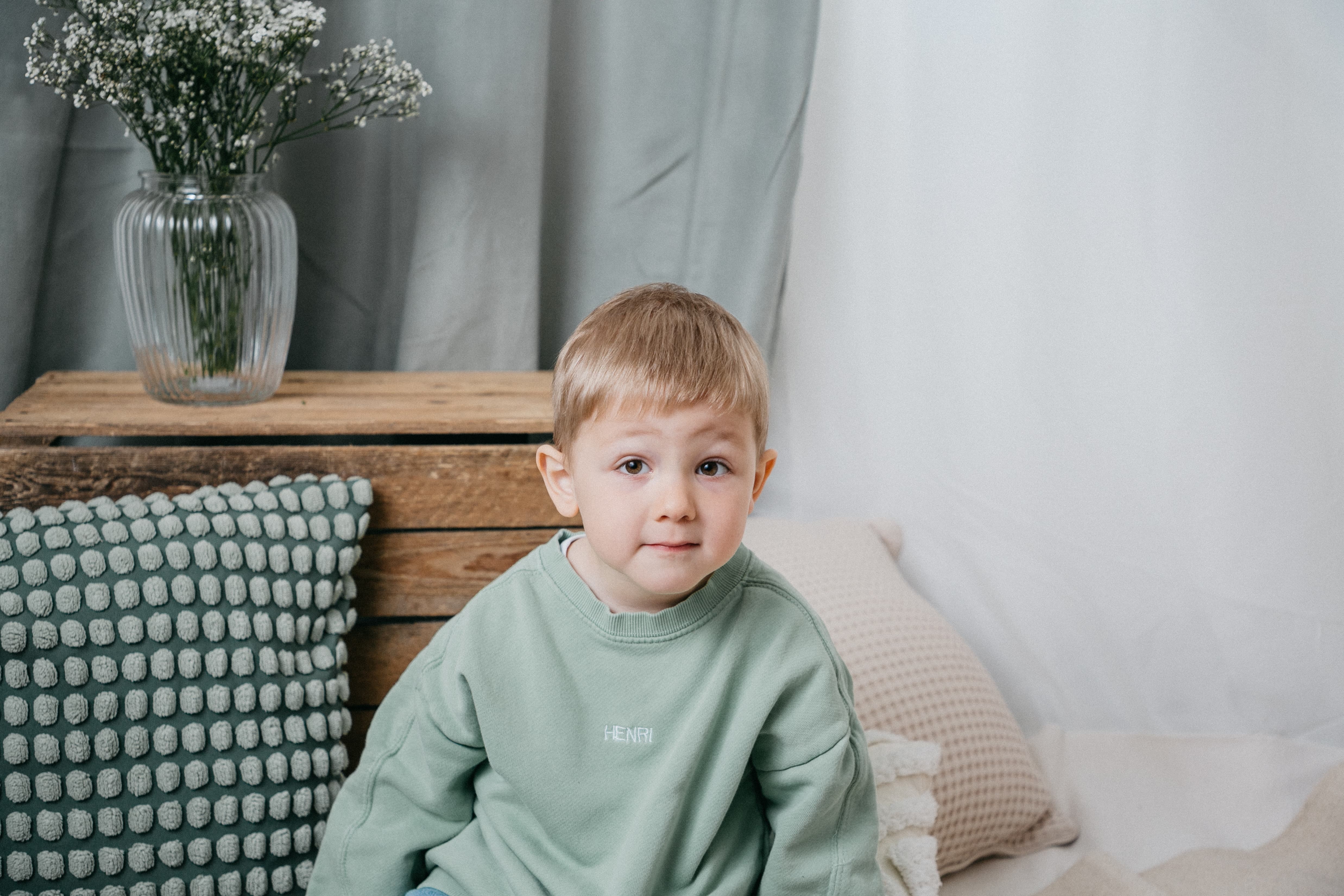 Junger Junge in dekoriertem Raum, der in Kamera schaut 