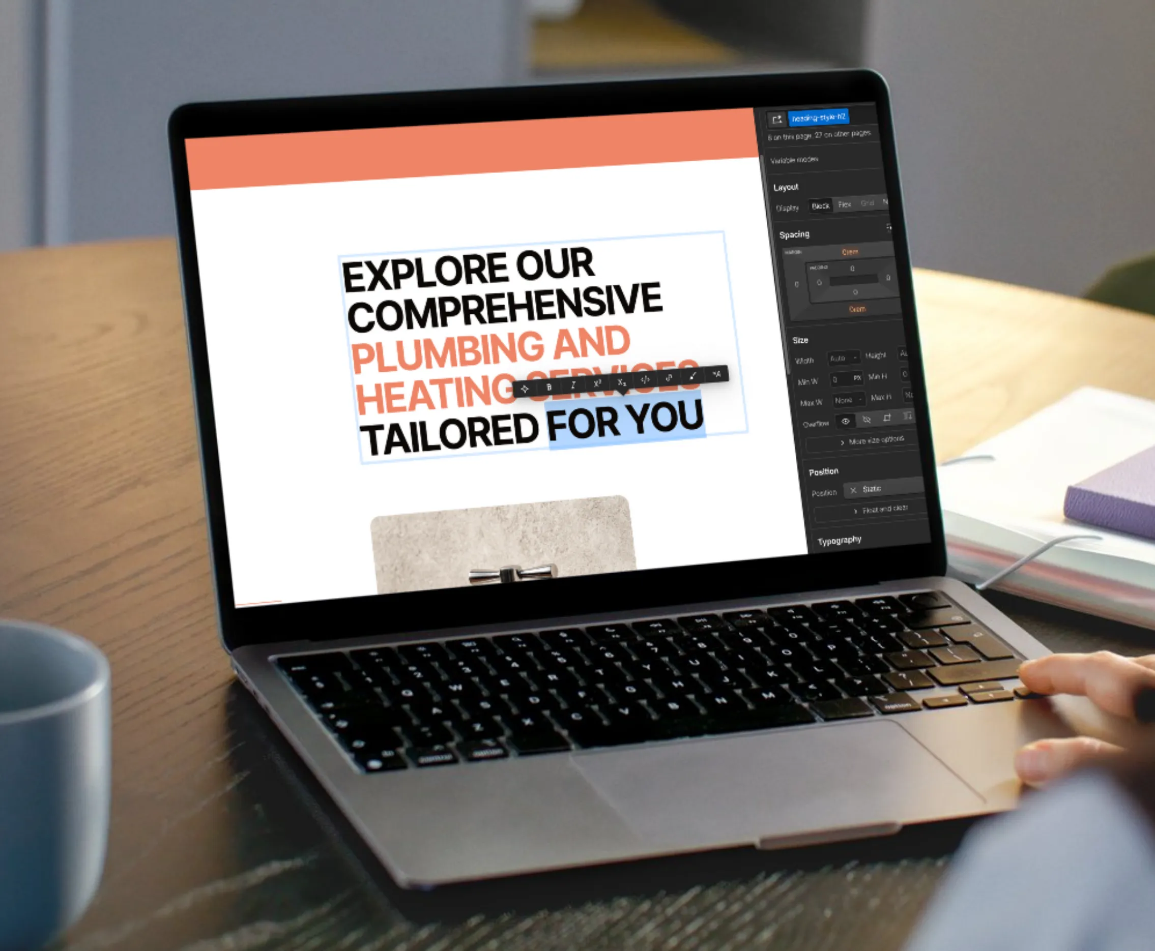 Laptop screen showing a website editor with text: 'Explore our comprehensive plumbing and heating services tailored for you.'