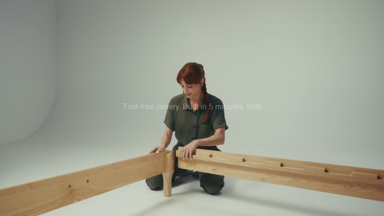 Woman assembling a timber bed frame in a creator-style video produced by Refined for Proferlo Furniture