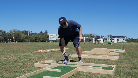 man playing mini golf