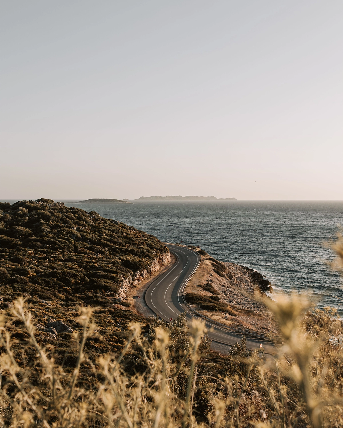 Coastal road winding along a rugged shoreline beside the sea