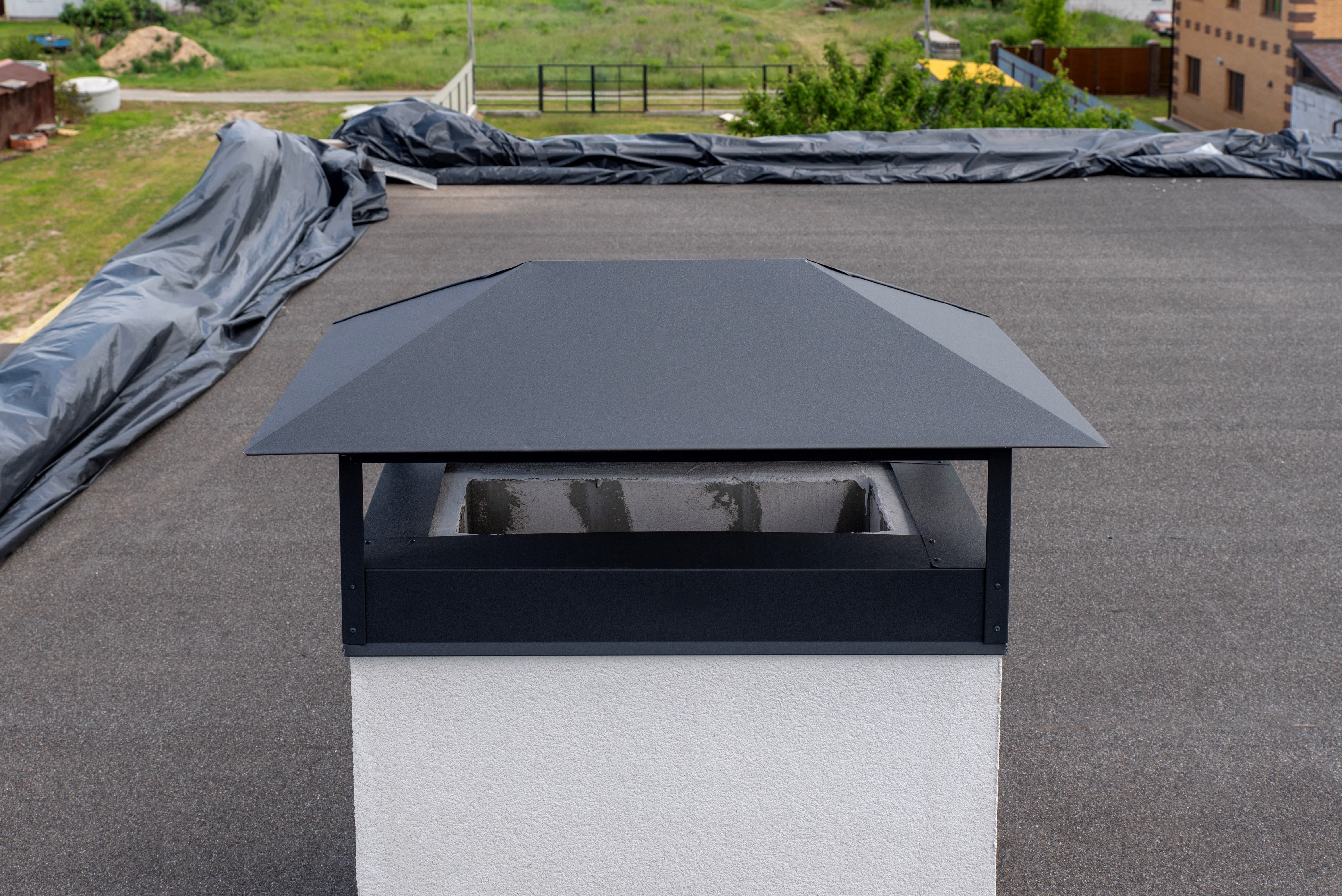 Close-up of stainless steel chimney cap on rooftop