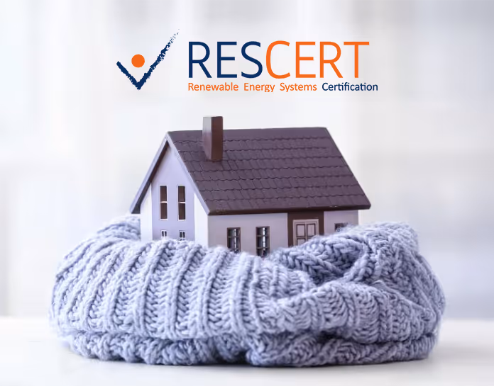 Maison miniature enveloppée dans un pull en laine gris, avec le logo RESCERT Renewable Energy Systems Certification en haut.