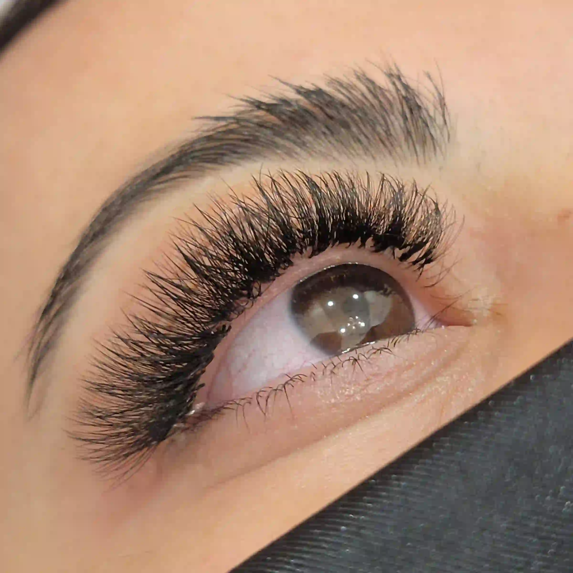 Upward angled close up of volume lash extensions with dramatic curl and full lash line, mobile lash service by Opalya in Toronto