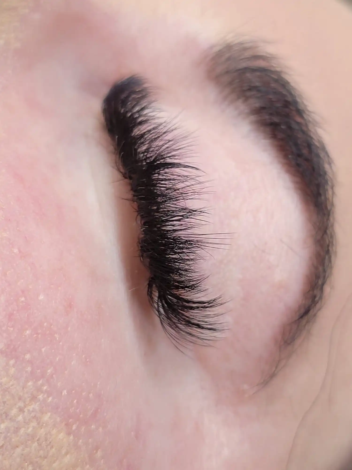 Side view of full volume lash extensions with soft curl and dense black finish, professional lash service by Opalya