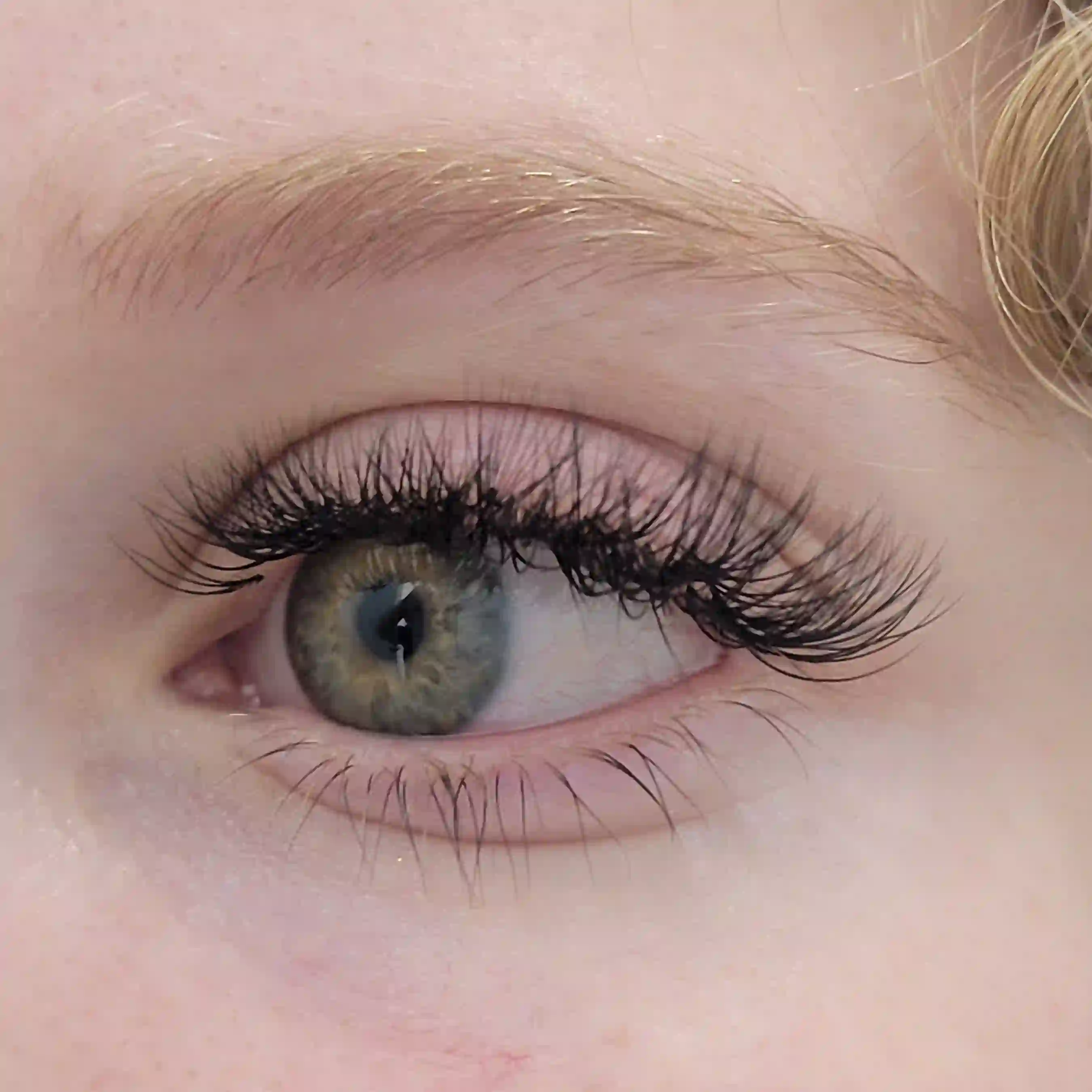 Close up of classic lash extensions on green eye with natural wispy effect and defined lash line, luxury lash treatment by Opalya