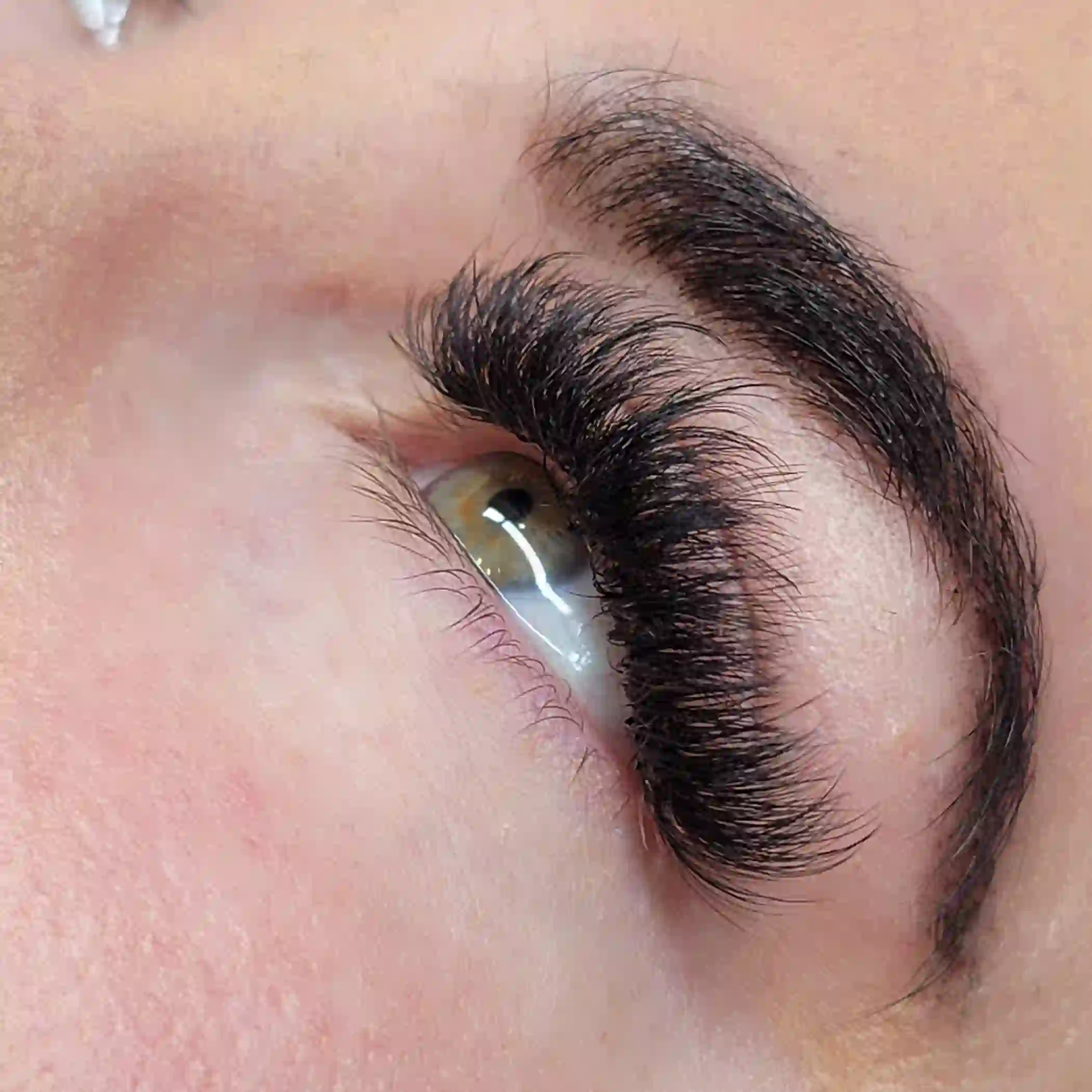 Angled view of hybrid lash extensions with layered length and natural density, premium lash service by Opalya mobile spa